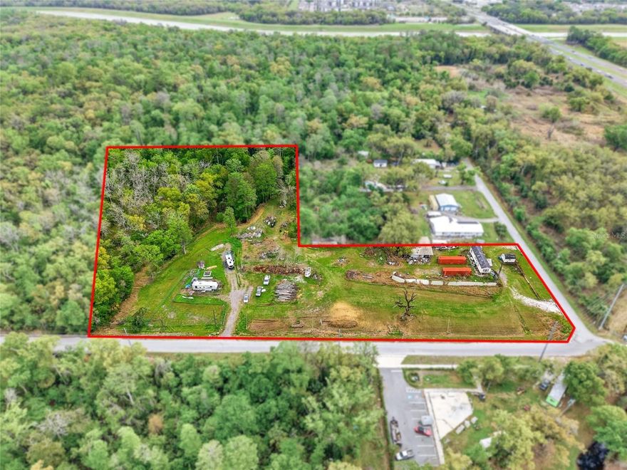 Rare corner acreage offering 700+ feet of unobstructed road frontage at the convergence of Tampa’s I-75 and I-4 corridors.

Approximately 5.01 acres located just off I-75 and within five miles of I-4, offering exceptional visibility, access, and long-term flexibility. This corner parcel features approximately 700+ feet of unobstructed road frontage with no buffer or setback restrictions impacting visibility, making it a highly visible and functional site.

The property is currently zoned AS-1, with neighboring parcels to the south zoned IH and to the west zoned CN, providing supportive surrounding context for future development subject to county approvals. The land is free of environmental contamination and includes a 250-foot deep, county-installed potable well, bi-annually tested. Unlike the south and west neighboring parcels, mandatory city water and sewer connection is not required, though municipal utilities are available approximately 1,000 feet away if desired.

Approximately 300 feet of seasonal creek frontage on both sides of the property may appeal to residential or mixed-use concepts, while the unrestricted frontage and visibility also support strong commercial or industrial potential.

There is an opportunity to assemble with adjacent parcels, whose owners are agreeable, creating an expanded footprint that may appeal to buyers seeking scale for commercial, industrial, or mixed-use development (conceptual). This parcel serves as a keystone site within the corridor due to its frontage, visibility, and positioning.

Co Buyer to verify all zoning, density, and development potential. FEMA flood designation is based on a 1980 panel. Buyers may pursue their own survey or FEMA LOMA if they wish to further evaluate the designation.