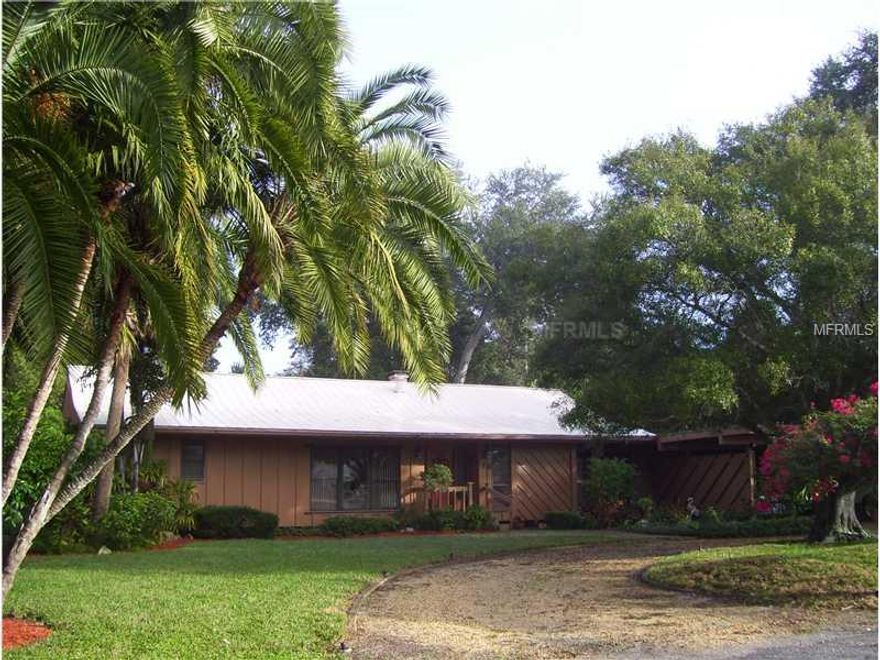 You will love the feel of this fabulous Florida home.  This is a home built with Cypress Wood(very hard) and the kind of craftsmanship you don't see anymore. This home was built "green" before "green" was a term. So many wonderful features: Lovely split plan with BIG bedrooms, cypress beamed, vaulted ceilings, plastered walls and ceilings, double paned windows in Living Room, solid wood interior doors, and the most fabulous 30x15 porch with pine floors and ceilings, cypress beams, and full window walls. Sitting on a lush, beautifully landscaped .41 acre lot makes it feel like it is in the middle of a park. There are many other wonderful features too: 10x24 workshop with 1/2 bath, sprinkler system on a deep well, wood burning fireplace in the living room, 36x36 attic fan in the hall (wonderful for cooling), central vacuum system, new roof and skylights on the porch in 2012, clear hurricane shutters, fabulous breezeway, over sized 2 car carport that is mostly enclosed (could easily be converted to garage). All of this in a neighborhood with access to the inter-coastal waterway, boat basin and 12 boat slips. There is currently a 6 deep waiting list for the boat slips. Slip Rental is $ 1,200 per annum.  You can't find this kind of home just anywhere.  This gem will disappear in a hurry. Seller offering an AHS Home Warranty at a cost NTE $ 405.
