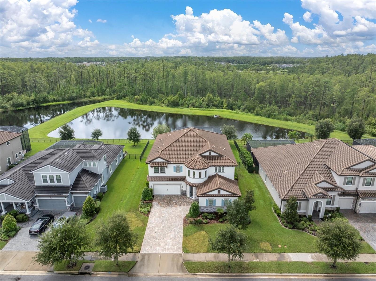 EXQUISITE ESTATE HOME WITH POOL & SPA ON .28 Acre CONSERVATION & POND LOT IN GATED ANCLOTE RESERVE! Captivating Homes By Westbay Maderia III is the epitome of luxury living spanning 4,218 sqft including 5 brs, 4.5 ba + Lg Bonus rm, office, 3 car split garage, pool +spa + OUTDOOR KITCHEN is situated on a FULLY FENCED lot w/ peaceful and private views. The curb appeal is enhanced by the Mediterranean Exterior Elevation, Tile roof, Stone accents, Shutters, Paver driveway, Etched Glass Door & Manicured Landscaping. As you enter the home, the grand foyer captures your attention with a soaring 22ft Rotunda vaulted ceiling enhanced w/ accent windows, 3 Chandeliers, & Hardwood staircase accented by Modern Wrought Iron spindles. Noteworthy upgrades include ceramic Tile floors throughout main living areas, new carpets in all bedrooms, new floors in bonus room, freshly painted Sherwin Williams Windfresh White interior, Plantation shutters and 8’ doors. To the right, French doors lead to the custom designed Executive office w/ stone wall, tray + ceiling fan. A dedicated formal dining rm w/ custom built ins provides functional space. This Impressive gourmet chef’s kitchen combines refined timeless style w/ versatile functionality. Classic Timberlake raised panel wood cabinets in Dove Gray are fashioned w/ crown, glass cabinets, under cabinet lighting, Satin Nickel hardware & Hexagon backsplash. Expansive Island offers level 6 Britannica Cambria quartz counters, pendant lights, & space for 4 bar stools. Equipped w/ GE Profile appliances featuring built in oven/microwave, 5 burner gas cooktop, modern chrome hood, dishwasher & Samsung 4 door refrigerator. A casual café dining space provides more seating. A spacious living room offers room to gather and is anchored by an elegant chandelier, designer wall paper & speakers. A full bedroom is located off the living room adjacent to a full bath w/ walk in shower that also serves as a pool bath. A half bath is situated near the kitchen. Ascend the staircase to the 2nd story bonus rm w/ brick accent wall, surround sound & new wood floors! This multi-purpose space offers endless possibilities. A delightful balcony overlooking the pond & trees will provide a lovely place to relax. The secluded Primary Bedroom is illuminated by a glamorous chandelier, cozy electric fireplace & sliders leading to balcony. Luxurious ensuite provides a spa-like escape w/ dual sinks, soaking tub, oversized walk in shower and 2 walk in closets w/ stylish custom closet organizers. Bedrooms 3 & 4 offer custom closets and share a Jack & Jill Bathroom. Br 5 is next to a full bath. Laundry Rm conveniently located on 2nd Fl provides cabinets, counters and utility sink. Pocketing sliders lead to your tranquil outdoor oasis. Resort style pool & spa w/ 2 story screened enclosure is an escape from it all w/ optimal privacy & views of nature, trees & pond. Relax in the heated saltwater pool & spa with deck jets + spill over bowls illuminated in evening by LED Multi-Color sconces. Entertain in style w/ newly built OUTDOOR KITCHEN & bar area or dine alfresco on the covered patio. Fully Fenced yard ensures safety. *Hurricane Shutters*Whole House Water Filtration*Reverse Osmosis*Video Doorbell & Cameras*Wifi Thermostats* Starkey Ranch offers an unparalleled lifestyle w/ its Magnet K-8 school, 3 community pools, playgrounds & 20 miles of trails. Close to Publix, Restaurants, Hospital, Tampa Airport & Beaches. Make this exquisite home yours.
