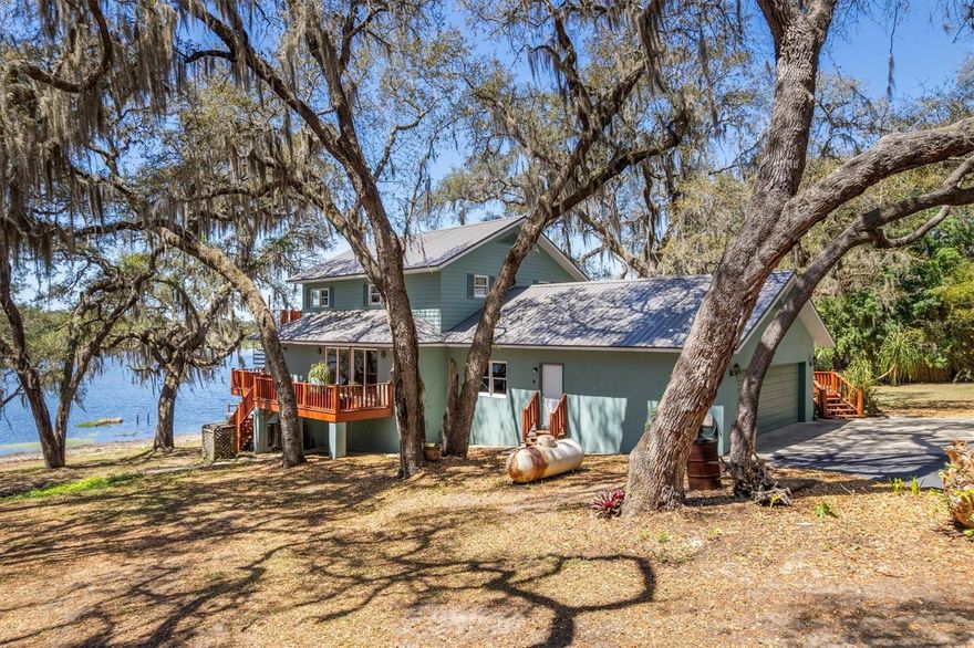 Set on nearly 19 private, agriculturally zoned acres, this exceptional 3-bedroom, 4-bath LAKEFRONT property offers the perfect blend of luxury living and outdoor lifestyle. Designed with versatility in mind, the acreage is ideal for horse lovers or other livestock - And room for you to roam, play, and enjoy! Centered around private Kirby Lake, the setting is both peaceful and recreational—perfect for water sports, fishing, or simply taking in the natural beauty that surrounds you. This is a true retreat where privacy and lifestyle come together.
The home has been extensively updated and meticulously maintained, featuring a NEW ROOF, two NEW HVAC systems, and a NEW hot water heater—delivering true move-in-ready confidence. Inside and out, the property has been freshly repainted and enhanced with upgraded lighting throughout, including the oversized, attached garage. Stylish stone countertops elevate the kitchen and baths, while updated flooring creates a cohesive, modern look to the home.  Puronics water treatment system ensures crystal clear water for drinking and bathing!  Outdoor living is easy, with a welcoming front porch, a screened lanai overlooking the lake, and large main AND upper-level decks designed to capture sweeping water views. The entertaining room with its dipping pool (complete with swim jets!) opens to an additional deck and  is certain to be a favorite for peaceful enjoyment or for entertaining your friends and family!  In addition to the stated sq footage, the lower level of the home offers a HUGE (730 Sq Ft) concrete block flex space with private entrance ready for your imagination—ideal for recreation, hobbies, or additional living options. The refinished driveway enhances both curb appeal and everyday functionality.  A large Quonset-style office/workshop on the property adds incredible flexibility. The acreage supports a wide range of uses—bring your horses, livestock, recreational vehicles, watercraft, and more!  Ideally located just 25 minutes to Gainesville, UF, and UF Health, approximately one hour to Ocala, and minutes to historic Melrose, this private estate offers a rare combination of seclusion, convenience, and endless potential.