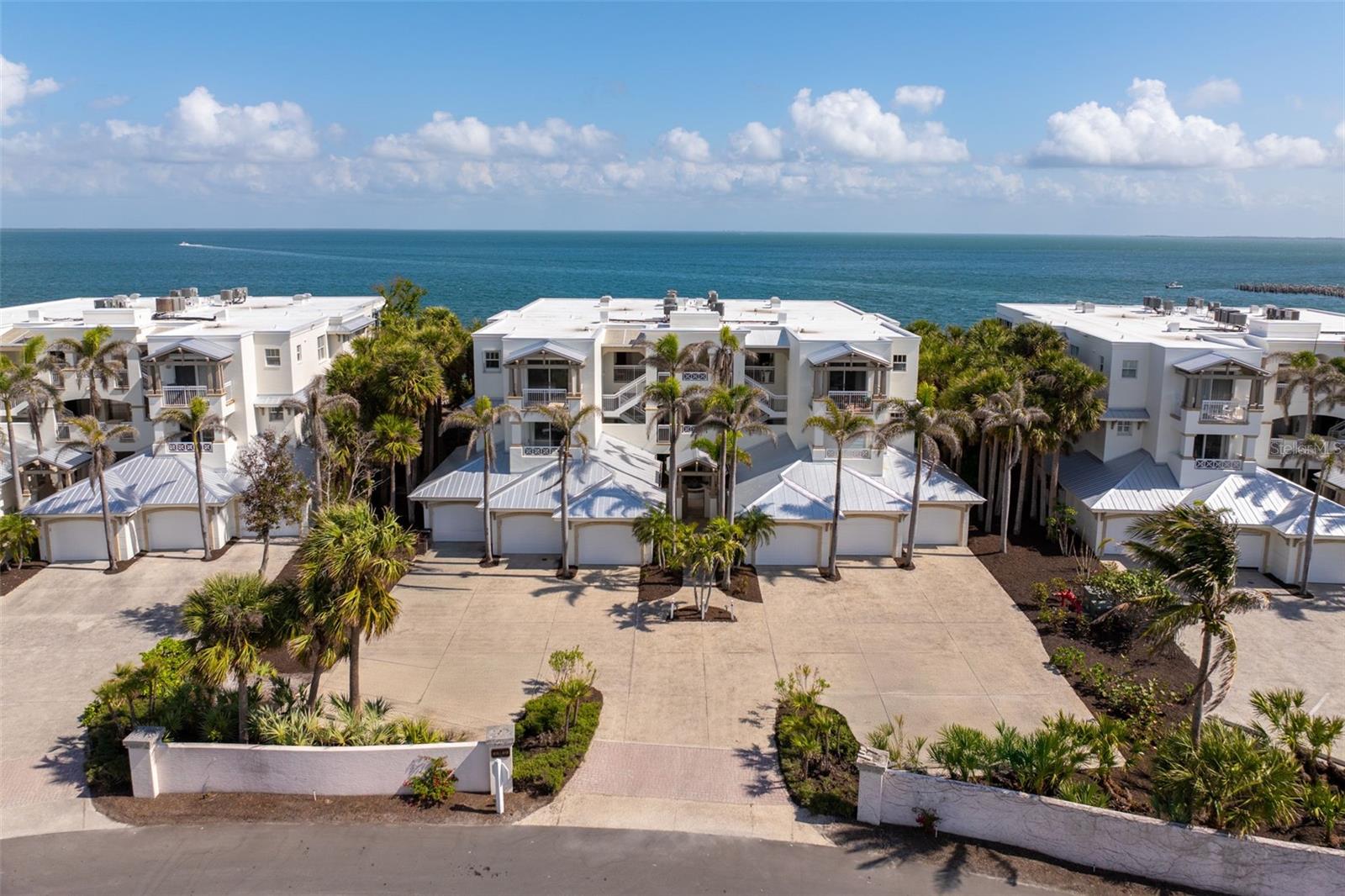 Nestled in one of Boca Grande's most coveted waterfront locations, this exquisite Harborshore condominium offers unparalleled bay views and luxury living. Located on the top floor, this 3-bedroom, 3.5-bathroom residence, plus den, presents a stunning open-concept design with elegant coastal style, clean lines, and a warm yet airy color palette. The living spaces have been carefully crafted to maximize breathtaking panoramic views of Charlotte Harbor, neighboring islands, and the wildlife-rich Boca Grande Pass, offering both sunrise and sunset vistas. The fully updated kitchen features custom shaker wood cabinetry, a sleek tile backsplash, Subzero refrigerator, Miele dishwasher, and a Wolf oven & microwave, perfect for the culinary enthusiast. The grand primary suite includes a large bedroom featuring built-in shelving, expansive walk-in closets, and direct bay views from its private terrace and a superbly remodeled bathroom that offers enhanced function with custom cabinetry, stone countertops, abundant storage, and a luxurious expanded shower adorned with beautiful tile work. Premium finishes throughout, including ceiling fans, California Faucets for most plumbing fixtures, and exquisite lighting fixtures complement the home's modern aesthetic. Step outside to impressive bar on the lanai, equipped with 2 Subzero beverage coolers, stunning cabinetry, and a stone countertop, ideal for entertaining or simply enjoying the view. The generously sized guest bedrooms each offer their own ensuite bathrooms, and the front guest room enjoys its own private terrace with Gulf views. The beautifully designed Harborshore buildings feature welcoming courtyards with fountains, and each residence includes a private one-car garage. Ideally situated near the bay front swimming pool and the renowned fishing pier extending out into the harbor, this community offers an abundance of outdoor enjoyment. Boca Bay is a premier coastal gated community that stretches over 1.5 miles along the waterfront, providing world-class amenities such as clay tennis and pickleball courts, a croquet court, fitness center, three resort-style swimming pools, a lap pool, miles of walking and biking paths, and community boat slips. The community's active and friendly atmosphere is complemented by its exquisite Gulf-front clubhouses offering gourmet dining and bar services. Enjoy an easy and picturesque bicycle or golf cart ride through the Boca Bay community right into downtown Boca Grande.