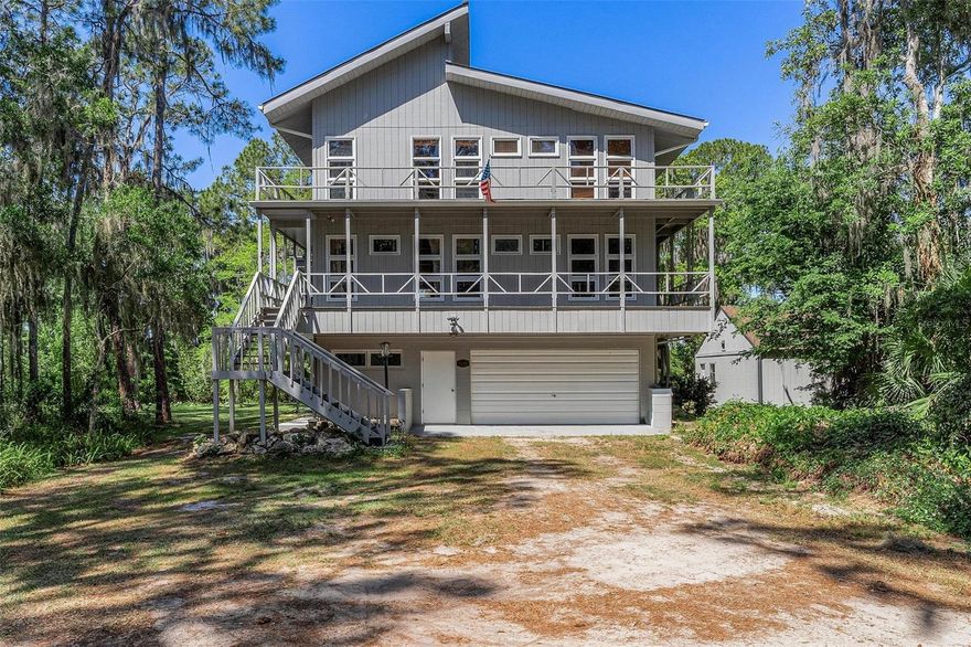 Welcome to the Tree House on the canal, leading to the Chain of Lakes, set on 1.37 acres on private Big Pine Island with only 13 homes. Step outside into your own nature-filled retreat. This property is designed for both relaxation and entertaining, featuring a private boat dock and plenty of space for gatherings, from weddings to graduation parties, all with a peaceful waterfront backdrop. Car enthusiasts and entertainers alike will appreciate the 4-car detached garage and additional 2-car attached garage. Enjoy breathtaking sunsets right over the canal each evening. Behind the canal, a 57-acre HOA-owned wooded wetlands parcel ensures lasting privacy and an unchanged natural view. This three-story home offers outdoor living on every level, including a first-floor covered porch, a second-floor wraparound balcony, and a third-floor balcony, allowing you to enjoy the surrounding beauty from every vantage point. Inside, the first floor features a private mother-in-law suite complete with a new mini-split system, full bathroom, and kitchenette. While not currently included in the home’s square footage, this approximately 380-square-foot space could be incorporated into the total living area with a few modifications. The second and third floors showcase stunning vaulted pine ceilings, pine flooring, and an abundance of windows that fill the open layout with natural light and capture panoramic views. The windows were strategically placed for energy efficiency and temperature control. A freestanding wood-burning stove with a central chimney is a unique eye-catcher and conversation starter that can warm the entire home in minutes. The primary bedroom is on the second floor with an en suite bath featuring granite counters. All bedrooms offer spacious walk-in closets, and all bathrooms have been remodeled. Recent upgrades include a commercial-grade standing seam metal roof 2023, updated electrical panels, a new AC system 2024, upgraded irrigation, and a rebuilt deck with new stairs and a dock finished with trex deck wood for long-term durability. Built with strength and longevity in mind, this home features a solid block first floor supported by a steel beam structure, along with hurricane preparedness elements such as generator plugs in the detached garage and emergency lighting throughout. The structural components are seamlessly integrated with wood accents, blending durability with design. In addition to your private dock, the property includes access to an HOA community boat launch. Why live in a box when you can live in this one-of-a-kind tree house, built to last and made for endless enjoyment?