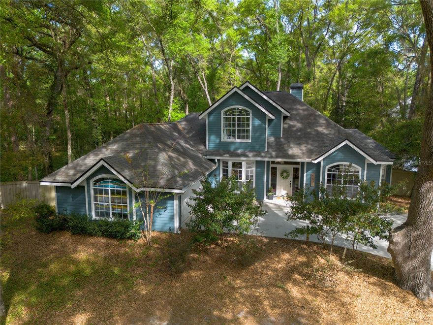 Picturesque and Serene Haile Plantation home! Tucked away at the end of a quiet cul de sac in the highly sought after Graham Mills neighborhood of Haile Plantation, this beautifully situated four bedroom, three bathroom home with a dedicated office offers the perfect blend of privacy, space, and convenience. Set on a wooded half acre lot, the property provides a peaceful, shaded retreat while still being just a short walk to Haile Village, home to charming boutiques, local restaurants, and the beloved Saturday farmers market. Inside, you are welcomed by a light filled living room featuring a cozy fireplace and large windows that frame picturesque views of the surrounding landscape. The living space flows seamlessly into the spacious kitchen and breakfast area, creating an ideal layout for both everyday living and entertaining. Just beyond, a flexible room currently used as an additional living area could easily serve as a formal dining room or gathering space to fit your needs. 

The thoughtfully designed split floor plan offers a private main level primary suite complete with a walk in closet and en suite bathroom with a large shower and expansive counter space. A second bedroom and full bathroom are also conveniently located on the first floor, making it ideal for guests or multigenerational living. Upstairs, you will find two additional bedrooms with beautiful window views and a shared bathroom, providing a comfortable and functional layout. Step outside to enjoy the expansive backyard, which is fully fenced, shaded, and incredibly private, offering plenty of room to relax, play, or entertain under the canopy of mature trees. Complete with plenty of storage space in this 2 plus car garage. This home offers a rare opportunity to enjoy the charm of Haile Plantation living with space, privacy, and walkability all in one. Don’t miss this one!