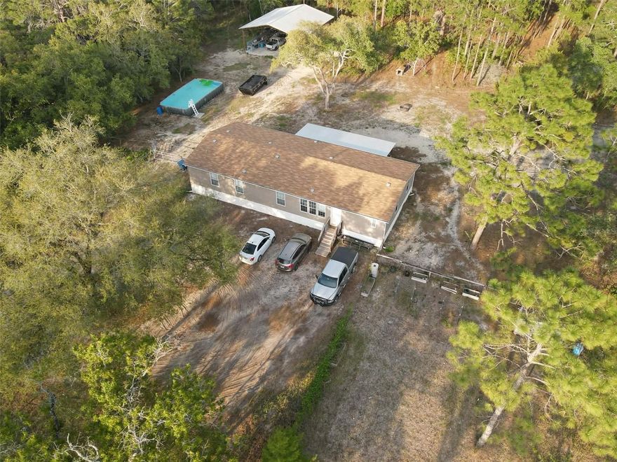 Country Living at its Finest!!  Just under 2.5 AC this is an Amazing Homestead that Leaves Nothing Unturned... Beautiful 4/3 Mobile Home with 2 Liv Areas, Huge Kitchen w/ Gobs of Cabinets, Large Dining Area, Living Room is Spacious and Opens into the Din/Kit but is Separate for Entertaining!  The Family/Gameroom currently Houses a Full Size Pool Table and a Minibar.  The Primary Bedroom is Oversized with an accommodating Bath with Walk-in Shower, Soaking Tub and Large Walk in Closet, plus a private bonus rm.  The 3 Auxiliary Bedrooms are Above Average in Size and there is a Jack n Jill Bath between Bedroom 2 and 3 and the 4th Bedroom has a Bath to itself.  There is a Great Utility Room with Loads of Storage, Shelving and Cabinets!  But Wait...Walk out onto the 32x12 Covered Deck that Overlooks Your New Fully Fenced in Playland...There's a Huge 34x16 Above Ground Pool, a 36x40 Pole Barn already plumbed for a FULL BATH!!  There's a Huge Double Chicken Coop, RV Hook Up WITH Sewer Cleanout, Raised Garden Beds, Muscadine Grapevines, Pic Nic Area, Firepit Area (this Firepit will not stay it was made for them) and what is really awesome... there's a Cleared Area for a Guest House,/Tiny Home/Bunkie or Whatever You might need with it's own Private Entrance off the Side Road!!!  Did I mention the Storage Container, how about another Storage Shed just for the Garden?! And plenty more but I don't want to totally blow your mind!!  This Place is Rocking It and is a Perfect Set Up for Multigenerational Living with the RV set up and the additional area for a second dwellling!!  All of this was built since 2022 and what an Amazing Place to Enjoy Life.  Literally out in the Middle of the Country but only 12 Minutes to Shopping, Real Shopping and Restaurants!! So much outdoor entertainment in the area ... come take a look!!