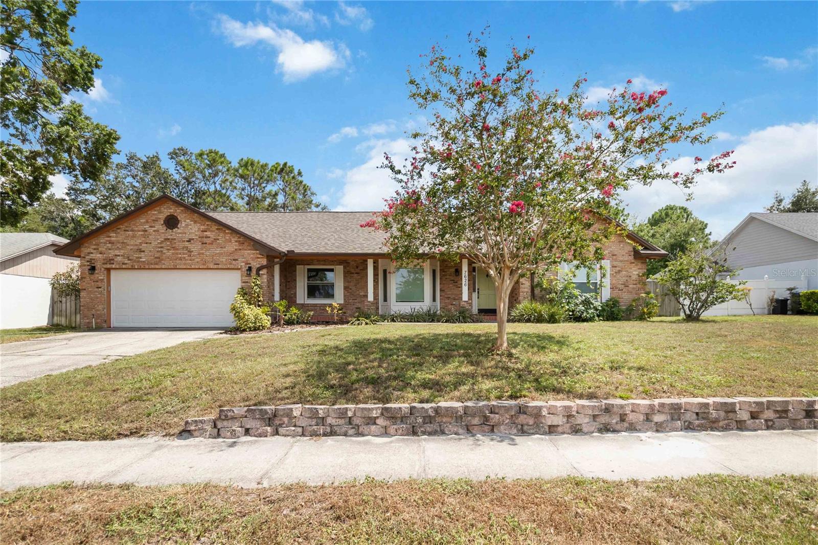 Welcome to this beautifully updated pool home in the desirable Hidden Springs community. Offering 3 bedrooms, 2 bathrooms, plus a versatile flex room perfect for an office, den, or guest space, this 2,103 sq ft home blends comfort and style with a layout designed for everyday living and entertaining. Step inside to find an open floorplan with soaring vaulted ceilings that create an airy, spacious feel. The formal dining area flows seamlessly into the living room, where custom built-in shelves and a charming fireplace provide warmth and character. Ceiling fans are installed throughout, and laminate flooring runs through the home, adding a cohesive, modern touch. The kitchen is both functional and inviting, featuring a large breakfast bar island, ample cabinet space, a convection oven, and a cozy dining nook that overlooks the pool. The primary suite offers a walk-in closet and a beautifully updated en suite bathroom with a teak double vanity, custom tile work, dual sinks, and a glass walk-in shower. Upgrades include new double-paned windows throughout, a new energy-efficient variable-speed A/C, and new double doors leading to the back patio. The laundry area features a newer energy-efficient washer and dryer, and the home also includes a new tankless hot water heater and a newer roof. But the true centerpiece of the home is the outdoor space. The expansive screened lanai features a sparkling in-ground pool with new pool plumbing, new tile, a resurfaced finish, and a spa that cascades into the main pool—perfect for relaxing or entertaining. A fully fenced yard with mature landscaping adds privacy and a peaceful feel. Located near lakes, shopping outlets, Universal Studios, and all that Orlando has to offer, this home also benefits from a voluntary HOA, giving you added flexibility. With thoughtful upgrades throughout and more to discover, don’t miss your chance to enjoy Florida living at its best in this move-in-ready gem.