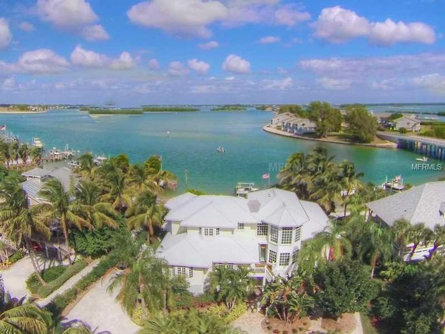 SANDY BEACH, DEEPWATER DOCK AND HEATED POOL-Award winning residential designer, Gerald R Maki, and long-time builder, Jack Curley, collaborated to create this beach-inspired custom home. Intended to take advantage of the vibrant water vistas, this design incorporates stylish windows, turrets and gables into an impressive, open floor plan ideal for entertaining guests or extended family. Spacious living room presents 20' ceilings, custom wood features and striking spiral staircase. First class kitchen is well equipped to handle a crowd with granite counters, stainless appliances and crafted wood cabinets. Main floor also includes combination family room and dining room, two en suite bedrooms complete with walk-in closets, and waterside all-weather porch with sliding glass doors. Privacy abound for the homeowners in the second floor owner suite, featuring a built-in desk/office area, spacious loft sitting area, and luxurious master bedroom with bead pine coved ceiling, spacious bathroom and sunny deck looking out towards the gulf. Heated pool and spa just steps from the beach, and abundant gardens with peaceful backyard seating enhances the allure of this property. Wired for an interior elevator, first floor has oversized two car garage with separate golf cart entrance and sizeable bonus space. Deep water dock with two lifts complete this fantastic island package.