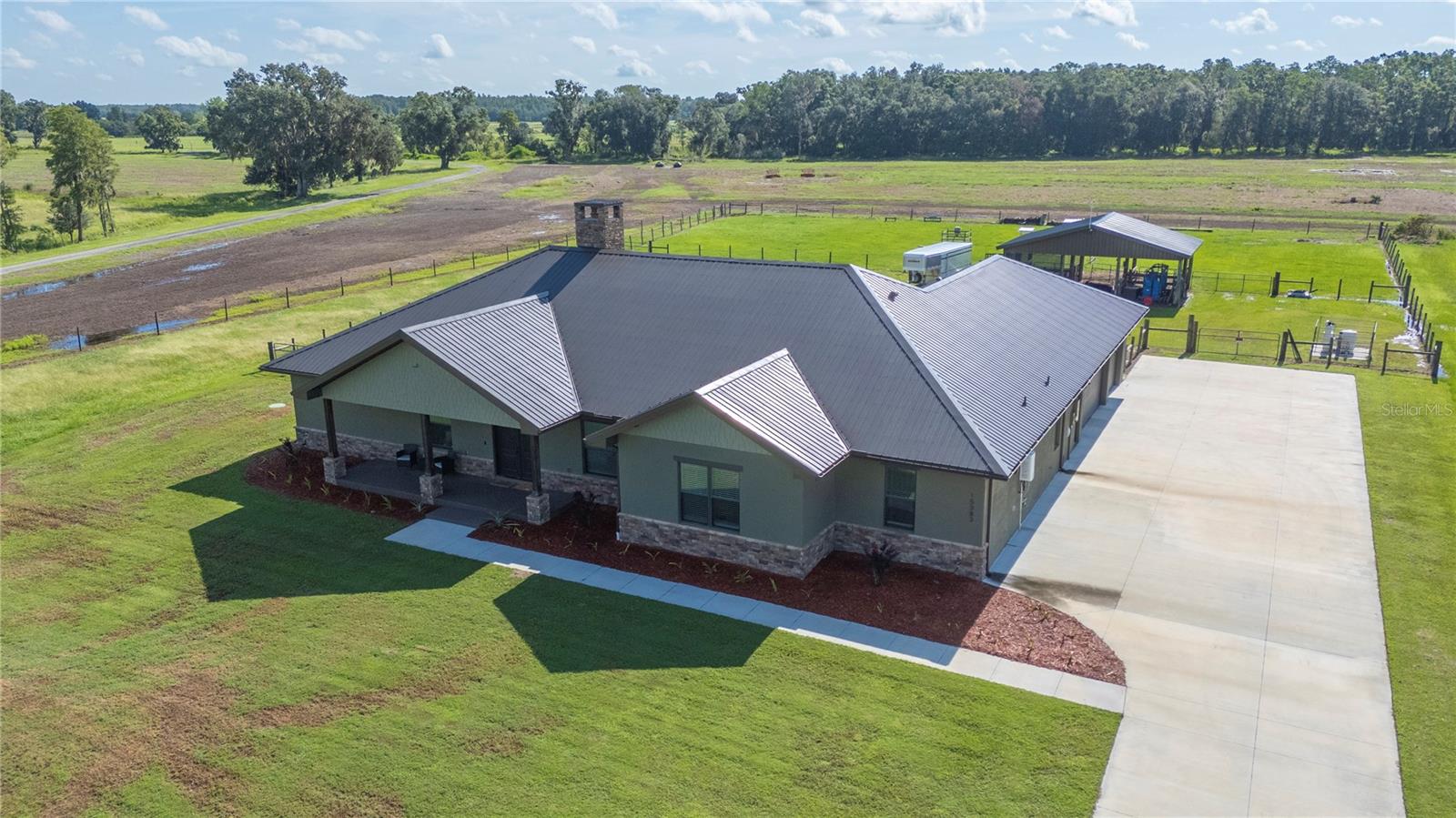 Welcome to this stunning 2023 custom-built home in gated North Lakeland, perfectly set on 1.68 acres. This 3-bedroom, 2-bath home offers 3,225 heated sq. ft. of open living space, plus a nursery/office off the primary suite and a versatile bonus room. Here, you’ll enjoy the perfect blend of country privacy and modern upgrades.
Property Highlights:
Barn & Livestock Ready: 12’x12’ stalls with automatic waterers/fans, storage stall for hay/equipment, and front/rear barn gates with a 10’ drive-through alley to pasture.
Full-Home Backup Power: 24 KW Generac generator with 500-gallon propane tank (10–12 days of whole-house power).
Spacious Interiors: Vaulted great room ceiling up to 17’, 10’ ceilings throughout, custom shelving in walk-in pantry.
Chef’s Kitchen: Gas stove with convection oven, butcher block counters in pantry, oversized 4’x10’ island with storage and power, LED under/over cabinet lighting.
Luxury Primary Suite: Nursery/office, dual sinks, garden tub, oversized 4’x8’ shower with bench and three shower heads, plus a large walk-in closet.
Extra Features You’ll Love:
Two A/C units for zoned comfort. 2 ton 16 SEER for the Master side of the home and a 5 ton 16 SEER unit for the remainder of the home
Walk-through attic storage accessible from master closet and garage — you can walk the length of the home
Custom 5.5-foot block masonry wood-burning fireplace
Dog wash/mudroom shower in laundry room
Site-built trusses for hurricane durability
Two tankless gas water heaters
Covered screened porch with quick-connect propane for grilling or gas fireplace
Outdoor Living & Curb Appeal:
Seamless gutters, Govee Pro LED soffit lighting, and room for gardening, recreation, or animal enclosures. Long paved driveway and 3-car garage for vehicles, equipment, or toys. Private well and septic system.
This property offers the space, functionality, and upscale finishes buyers want—without sacrificing the charm of a rural lifestyle. **Set up your appointment today to see it and click on the virtual tour button for a Matterport 360 degree tour of the home. Just like a 24/7 open house!
