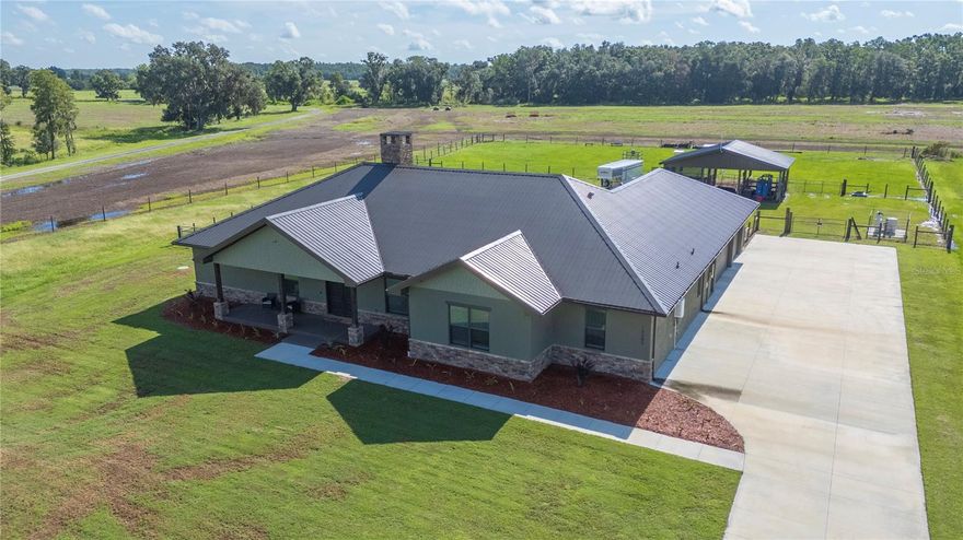 Welcome to this stunning 2023 custom-built home in gated North Lakeland, perfectly set on 1.68 acres. This 3-bedroom, 2-bath home offers 3,225 heated sq. ft. of open living space, plus a nursery/office off the primary suite and a versatile bonus room. Here, you’ll enjoy the perfect blend of country privacy and modern upgrades.

Property Highlights:

Barn & Livestock Ready: 12’x12’ stalls with automatic waterers/fans, storage stall for hay/equipment, and front/rear barn gates with a 10’ drive-through alley to pasture.

Full-Home Backup Power: 24 KW Generac generator with 500-gallon propane tank (10–12 days of whole-house power).

Spacious Interiors: Vaulted great room ceiling up to 17’, 10’ ceilings throughout, custom shelving in walk-in pantry.

Chef’s Kitchen: Gas stove with convection oven, butcher block counters in pantry, oversized 4’x10’ island with storage and power, LED under/over cabinet lighting.

Luxury Primary Suite: Nursery/office, dual sinks, garden tub, oversized 4’x8’ shower with bench and three shower heads, plus a large walk-in closet.

Extra Features You’ll Love:

Two A/C units for zoned comfort. 2 ton 16 SEER for the Master side of the home and a 5 ton 16 SEER unit for the remainder of the home

Walk-through attic storage accessible from master closet and garage — you can walk the length of the home

Custom 5.5-foot block masonry wood-burning fireplace

Dog wash/mudroom shower in laundry room

Site-built trusses for hurricane durability

Two tankless gas water heaters

Covered screened porch with quick-connect propane for grilling or gas fireplace

Outdoor Living & Curb Appeal:
Seamless gutters, Govee Pro LED soffit lighting, and room for gardening, recreation, or animal enclosures. Long paved driveway and 3-car garage for vehicles, equipment, or toys. Private well and septic system.

This property offers the space, functionality, and upscale finishes buyers want—without sacrificing the charm of a rural lifestyle. **Set up your appointment today to see it and click on the virtual tour button for a Matterport 360 degree tour of the home. Just like a 24/7 open house!