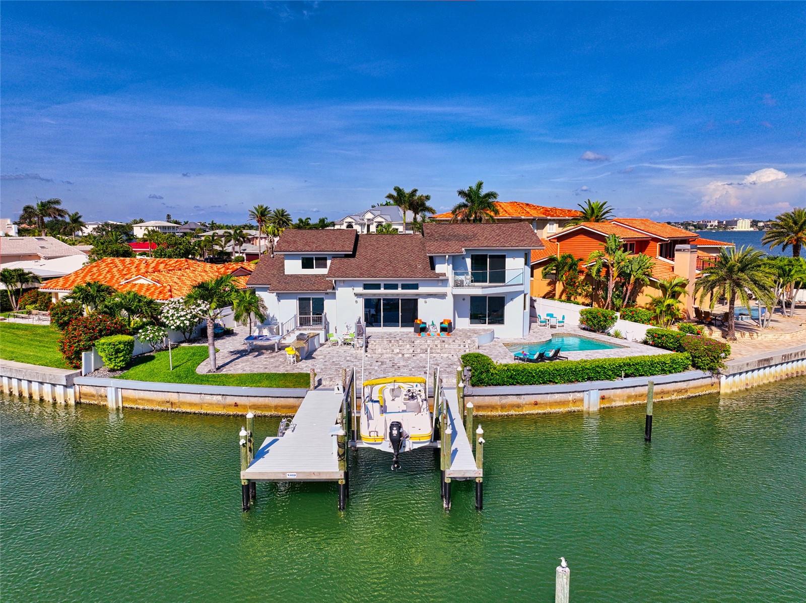 BRAND NEW WHITE GLOSS KITCHEN CABINETS AND NEWLY UPDATED HALF-BATH! Welcome to your ultimate Florida escape! Step into a fully remodeled and freshly painted waterfront haven that radiates CONTEMPORARY elegance. Nestled in a peaceful cul-de-sac within the highly sought-after Belleair Beach community, this extraordinary property offers breathtaking views that will steal your heart away.
From the moment you step inside, natural light floods the living room, creating a warm and inviting ambiance. Cathedral ceilings soar above, while wall-to-wall glass doors unveil an awe-inspiring panorama of the intracoastal waterway. Every glance outside is a window into paradise.
Prepare to be captivated by the kitchen, a masterpiece boasting BRAND NEW, stunning bright-white gloss cabinets and NEW backsplash, top-of-the-line appliances, and a delightful breakfast seating area. As you savor a meal, your eyes are treated to a symphony of beauty, with the waterfront dancing just beyond your fingertips.
The first floor hosts two charming bedrooms, divided by a beautifully tiled bathroom exuding sophistication, as well as a BRAND NEW half-bathroom with glass and chrome sink. Ascend the stairs to an architectural marvel—a sleek catwalk enveloped in transparent glass railings, guiding your way to the bedrooms. To the right, discover a cozy retreat, while to the left, the master suite beckons.
The master suite is a sanctuary that embraces you with its enchanting water views and a private balcony, perfect for sipping your morning coffee as the world awakens. The master bathroom is a testament to indulgence, featuring a spacious glass tile shower with a waterfall shower-head and more mesmerizing vistas. Luxurious LUBE ITALIAN vanities and countertops elevate the experience, while a generous walk-in closet awaits to fulfill your fashion desires.
Venturing back downstairs, step onto the Italian TRAVERTINE PATIO and embrace the true essence of waterfront living. Take a refreshing swim in the pool, bask in the sun's warm embrace, and rinse off in the outdoor shower. Keep a watchful eye for the delightful company of dolphins, stingrays, and manatees, who gracefully travel these waters day after day.
A brand new dock on 150 FEET OF WATER FRONTAGE, crafted with Barefoot Gray Wear Decking, presents a 10,000-pound boat lift and an expansive YACHT SLIP, inviting you to embark on exciting aquatic adventures. 72' BRIDGE right down the road past Bird Key Park allows for quick, easy GULF ACCESS. Indulge in the art of outdoor cooking with your TYTUS grill, while a brand new mini-fridge keeps your beverages cool and refreshing. Delight in the fragrant embrace of Frangipani trees as you unwind in the outdoor seating area, catching up on your favorite shows on the OUTDOOR TV.
Seek respite from the summer heat under the shade of the 25' electric remote awning, where you can recline and relish in the comforts of this tranquil oasis. As the sun sets, the LED lights embedded in the awning illuminate the scene, while automatic solar night-time soft blue lights cast a magical glow over the home's exterior. Enhance the atmosphere with your preferred tunes using the state-of-the-art indoor/outdoor SONOS system.
RESIDENT ONLY PARKING ACCESS TO BEACHES! Your Florida dream awaits—embrace the "air" of Belleair today!