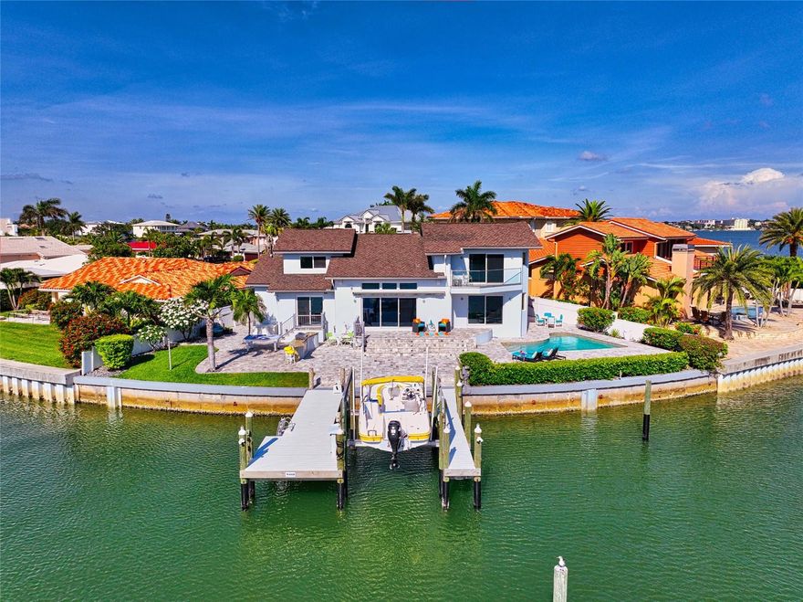 BRAND NEW WHITE GLOSS KITCHEN CABINETS AND NEWLY UPDATED HALF-BATH! Welcome to your ultimate Florida escape! Step into a fully remodeled and freshly painted waterfront haven that radiates CONTEMPORARY elegance. Nestled in a peaceful cul-de-sac within the highly sought-after Belleair Beach community, this extraordinary property offers breathtaking views that will steal your heart away.

From the moment you step inside, natural light floods the living room, creating a warm and inviting ambiance. Cathedral ceilings soar above, while wall-to-wall glass doors unveil an awe-inspiring panorama of the intracoastal waterway. Every glance outside is a window into paradise.

Prepare to be captivated by the kitchen, a masterpiece boasting BRAND NEW, stunning bright-white gloss cabinets and NEW backsplash, top-of-the-line appliances, and a delightful breakfast seating area. As you savor a meal, your eyes are treated to a symphony of beauty, with the waterfront dancing just beyond your fingertips.

The first floor hosts two charming bedrooms, divided by a beautifully tiled bathroom exuding sophistication, as well as a BRAND NEW half-bathroom with glass and chrome sink. Ascend the stairs to an architectural marvel—a sleek catwalk enveloped in transparent glass railings, guiding your way to the bedrooms. To the right, discover a cozy retreat, while to the left, the master suite beckons.

The master suite is a sanctuary that embraces you with its enchanting water views and a private balcony, perfect for sipping your morning coffee as the world awakens. The master bathroom is a testament to indulgence, featuring a spacious glass tile shower with a waterfall shower-head and more mesmerizing vistas. Luxurious LUBE ITALIAN vanities and countertops elevate the experience, while a generous walk-in closet awaits to fulfill your fashion desires.

Venturing back downstairs, step onto the Italian TRAVERTINE PATIO and embrace the true essence of waterfront living. Take a refreshing swim in the pool, bask in the sun's warm embrace, and rinse off in the outdoor shower. Keep a watchful eye for the delightful company of dolphins, stingrays, and manatees, who gracefully travel these waters day after day.

A brand new dock on 150 FEET OF WATER FRONTAGE, crafted with Barefoot Gray Wear Decking, presents a 10,000-pound boat lift and an expansive YACHT SLIP, inviting you to embark on exciting aquatic adventures. 72' BRIDGE right down the road past Bird Key Park allows for quick, easy GULF ACCESS. Indulge in the art of outdoor cooking with your TYTUS grill, while a brand new mini-fridge keeps your beverages cool and refreshing. Delight in the fragrant embrace of Frangipani trees as you unwind in the outdoor seating area, catching up on your favorite shows on the OUTDOOR TV.

Seek respite from the summer heat under the shade of the 25' electric remote awning, where you can recline and relish in the comforts of this tranquil oasis. As the sun sets, the LED lights embedded in the awning illuminate the scene, while automatic solar night-time soft blue lights cast a magical glow over the home's exterior. Enhance the atmosphere with your preferred tunes using the state-of-the-art indoor/outdoor SONOS system. 

RESIDENT ONLY PARKING ACCESS TO BEACHES! Your Florida dream awaits—embrace the "air" of Belleair today!