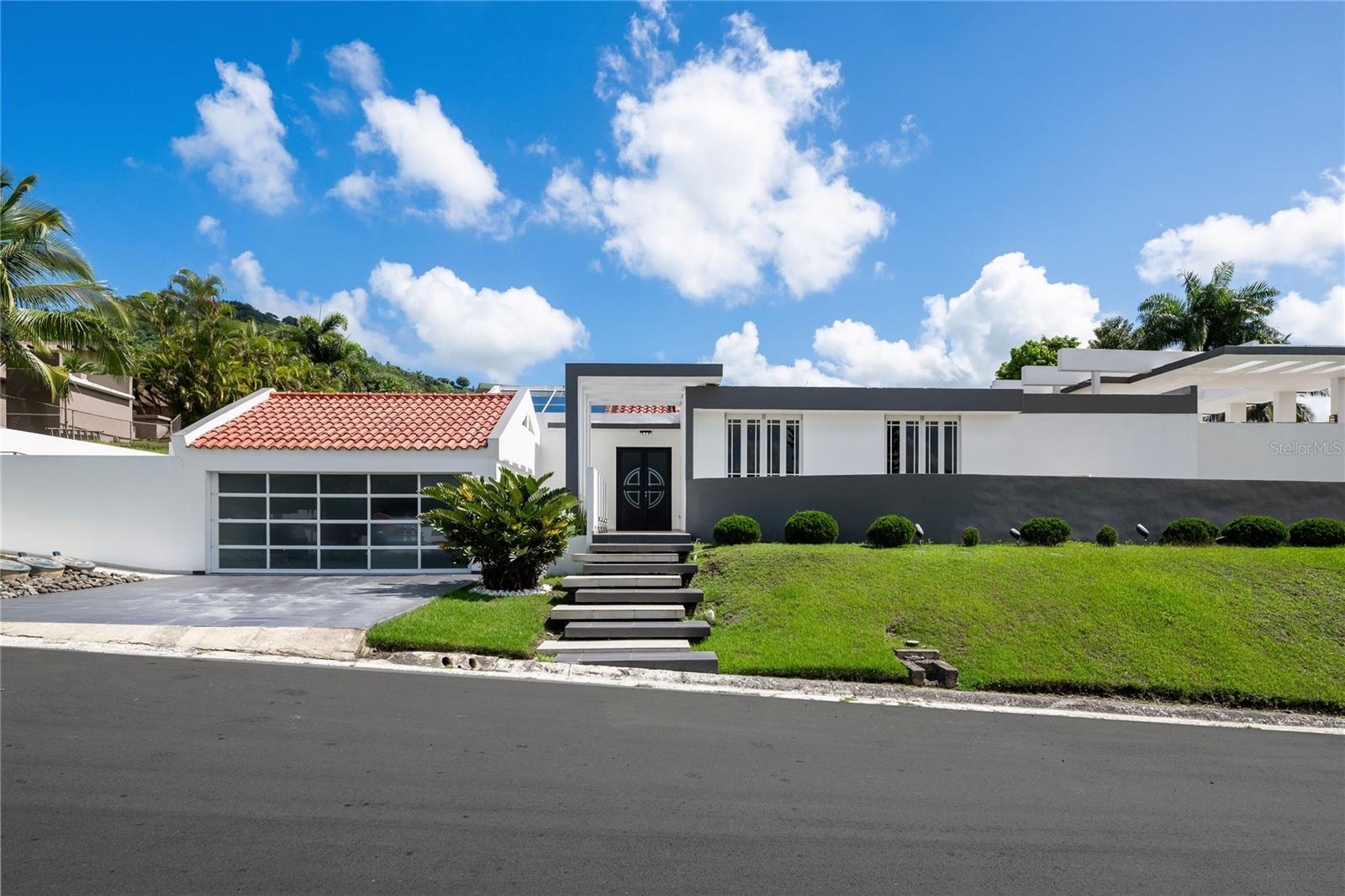 Located in the exclusive Laderas de San Juan community, this stunning residence of 4,300 sq. ft. of construction redefines modern elegance and comfort. Set on an expansive 1,613 m² lot, the property blends impeccable architectural design with high-end finishes and thoughtful amenities that elevate everyday living.
The home features 4 spacious bedrooms, 4.5 bathrooms, a private office, and two family or entertainment areas, perfect for both relaxation and social gatherings. The covered terrace seamlessly connects to the swimming pool area, creating a outdoor space ideal for entertaining.
The gourmet kitchen comes fully equipped with top-of-the-line appliances, including a freezer, wine cooler, ice maker, microwave, cooktop, oven, hot drawer, and dining set . The property also includes 7 air conditioning units, a 12KW power generator, 600-gallon water cistern, on-demand water heater, and a two-car garage with storage area.
Elegant details and select furnishings enhance its luxurious ambiance, including a fountain sculpture, decorative lighting fixtures in the living, dining, and family rooms, three bedroom TVs, underground trash bins, pool cleaning robot, washer, and dryer, among other features.
Every corner of this home has been thoughtfully designed to deliver an exceptional living experience — where luxury, comfort, and privacy meet in perfect harmony.