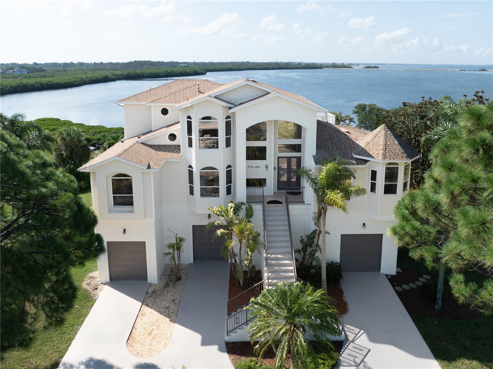 Welcome to your private paradise on the Gulf—an extraordinary coastal estate offering the perfect blend of luxury, comfort, and breathtaking beauty. Situated on a rare double lot with 140 feet of pristine Gulf frontage, this meticulously designed residence spans 0.49 acres and features 5 bedrooms, 3 full baths, 2 half baths, 4092 heated square feet of living space, 7,500 total sqft under roof. From the moment you arrive, the home’s stunning curb appeal captivates, lush tropical landscaping, circular driveway, a grand front stairs flanking an impressive double-door entryway. Inside, a 20-foot ceiling soars above the entrance, framing unobstructed panoramic water view! The main level has extensive Italian porcelain tiles, dazzling floor-to-ceiling tinted double paned windows, French doors and walls of sliding doors throughout. Chef's kitchen is recently renovated with new marbling white countertops and new fixtures, top-of-the-line Subzero fridge, Thermidor gas cook station with food-warming shelves, and new LG double wall-oven. This floor has two living rooms, a gas fireplace, two dining rooms, and three en-suite bedrooms, with stunning water view from nearly every room! Step outside to the expansive screened-in large balcony, with unobstructed magnificent gulf view! Enjoy sunrises, sunsets, dolphins at play, and soaking in the serenity! An artistic custom built wrought iron railing and floating staircase leads you upstairs, where you will find the primary suite offers spectacular water views, a spa-inspired bath with separate vanities, a spacious walk-in shower, a large walk-in closet, plus a private roof level sun deck with panoramic views of the Gulf! The fifth bedroom/office is also on this level with an impressive water view! The ground level boasts a resort-style heated pool, an outdoor shower, a beautiful paver pool deck, plus an expansive covered entertainment area equipped with an outdoor bar, perfect for any pool party or family celebration. A versatile bonus living area complete with a large bedroom, a media room, and a peaceful Zen space—perfect for guests, a gym, or creative studio. Beyond the pool, a Private observation dock with new composite wood, and jet ski dock provides you with endless options for water activities, kayaking, pedal boarding, fishing, jet skiing, scalloping, crabbing… you will never run out of options! Fenced large backyard will make your fur baby so happy. Did I mention there’s a three stop elevator gives you access to all levels? feeling lazy? Take the elevator! No HOA or CDD, no deed restrictions, you can park your boat, your RV, no storage needed. 3-car garage plus a workshop area provides abundant of parking and room for home improvement projects! Located close to major highways and two International Airports, only minutes from world-class sugar white sand beaches, golf courses, nature preserves/parks, and the charming historic town of Tarpon Springs, once known as the "Venice of the South" and today hailed as the "Sponge Capital of the World"—you'll find a rich mix of culture, art, and culinary surprises. Enjoy delectable Greek/Mediterranean cuisine, vibrant festivals, boat parades, and a fun and welcoming community that makes every day feel like a celebration. This is more than a home—it’s a waterfront lifestyle defined by natural beauty, and timeless elegance. Don’t just dream it, live it! Schedule your showing today and experience the lifestyle you’ve always imagined.