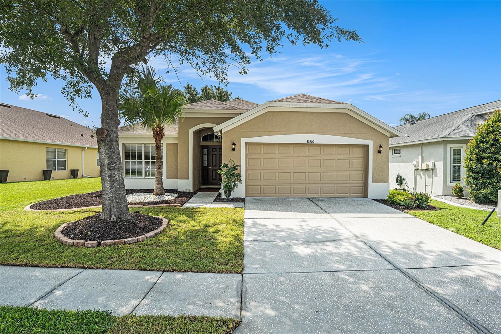 A warm and welcoming 4 bedroom home with stunning views overlooking a tree lined pond. Relax and decompress sitting on your screened lanai, soaking in the sounds and sights of nature. Enjoy peace of mind with a Brand New Roof (2025), newer Gas water heater (2021), and recently painted exterior (2025). The kitchen is a chef's delight with 42" cabinets with crown molding, granite countertops, natural gas range, double door pantry, and abundant storage and countertop space for both prep and serving. Enjoy low maintenance flooring throughout with Engineered Hardwood in the family room, Diagonal Tile in the remaining living and all wet areas, and newer carpet in the bedrooms. The primary bathroom includes a large shower, separate luxury garden tub, dual sinks, private water closet, and leads to an enormous closet. Meadow Pointe is an Award-winning neighborhood in Pasco County with highly rated schools and phenomenal amenities. Clubhouse III is within walking distance and includes a resort style pool, covered playground, lighted tennis, basketball, shuffleboard, beach volleyball courts, and a fitness center. Convenient to the Premium Outlet Mall and the Shoppes at Wiregrass Mall, with several new restaurants and medical facilities nearby. Easy Access to I-75, I-4, I-275, USF, Busch Gardens, Orlando, and the beaches. Call Today to Tour this Beautiful Home!