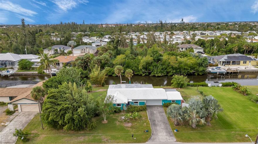 One or more photo(s) has been virtually staged. Discover your dream waterfront retreat in Punta Gorda, FL, with this enchanting property that offers a rare combination of space, privacy, and direct access to nature's beauty. Perched on a generous a DOUBLE LOT with 140 feet of waterfront, this home is not just on the water—it's a gateway to a lifestyle filled with aquatic adventures and serene views.

This three-bedroom, two-bath residence seamlessly blends old Florida charm with modern upgrades. Step inside to find hard floors throughout, a spacious kitchen perfect for culinary explorations, a newer washer and dryer, and a brand-new dishwasher, ensuring comfort and convenience in your daily life. The home is further equipped with hurricane shutters and impact windows, providing safety and peace of mind. The whole house has been RE-PIPED and an eco-friendly hot water tank added.

The property's unique location on two spacious lots in Punta Gorda is a rare find, offering ample room and privacy. You're not just buying a home; you're acquiring a personal sanctuary with space on either side, unlike the typical crowded neighborhood setting. The outdoor space is a highlight, featuring four beautifully manicured garden beds that create a private Eden for you to enjoy.

Boating enthusiasts will appreciate the easy boat trip to open waters, with quick and fun excursions to places like the Riviera Bar and Marina for a delightful dinner by the sea. The proximity to downtown adds to the convenience and appeal of this location.

For those who love to tinker or need extra storage, the two-car garage with a large attached workshop is a dream come true. Additionally, the seller owns three lots across the canal, presenting a unique opportunity for expansion or further investment.

This property is perfect for anyone coming to Florida to enjoy the great outdoors or seeking a lucrative AirBNB opportunity in a fantastic location with a dreamy, natural setting. Whether it's your primary residence or an investment property, this Punta Gorda gem offers a blend of waterfront living, charm, and modern amenities that is hard to match. Don't miss the chance to own this slice of Floridian paradise!