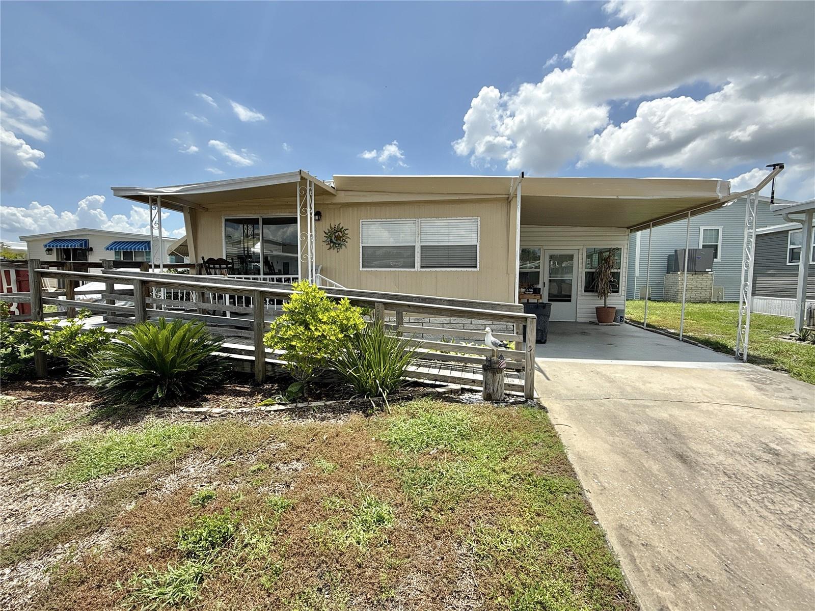 Walk to the community park from this excellent location on a short quiet street! No flooding inside with 2024 storms! This 2 bed/1.5 bath home with 1,088 sq ft of air conditioned living space has been lovingly maintained. The features are many: 2025 central a/c and ductwork, 2024 vapor barrier to protect the subflooring, 2022 plumbing, 2022 termite treatment with annual inspection thereafter, 2025 upgraded sprinkler system, 2017 roofover and 2013 water heater and windows. The home has laminate flooring throughout, stainless appliances in kitchen with lots of cabinet space, drywall on ceilings and walls throughout, large primary bedroom with walk-in closet and ensuite half bath and utility closet with full-size washer and dryer in second bedroom. Enclosed Florida room with shed increases the living space. Front ramp to sliding doors can be removed, if desired. Price includes share for the lot and ownership in the co-op. Low monthly maintenance fee of $380 includes water/sewer/trash pick up/lawn mowing/24 hr manned gate/private streets and all amenities including heated pool, clubhouse, fitness center, billiards, two boat ramps and kayak launch and so much more! Two pets (dogs or cats) up to 35 pounds are welcomed! Use home as a primary residence or vacation retreat or make it a rental property as renting is allowed with 2 month minimum. Popular Americana Cove is a 55+ community located only 10 mins to downtown St. Petersburg, 15 mins to two airports and 25 mins to beautiful Gulf beaches. What a great value!