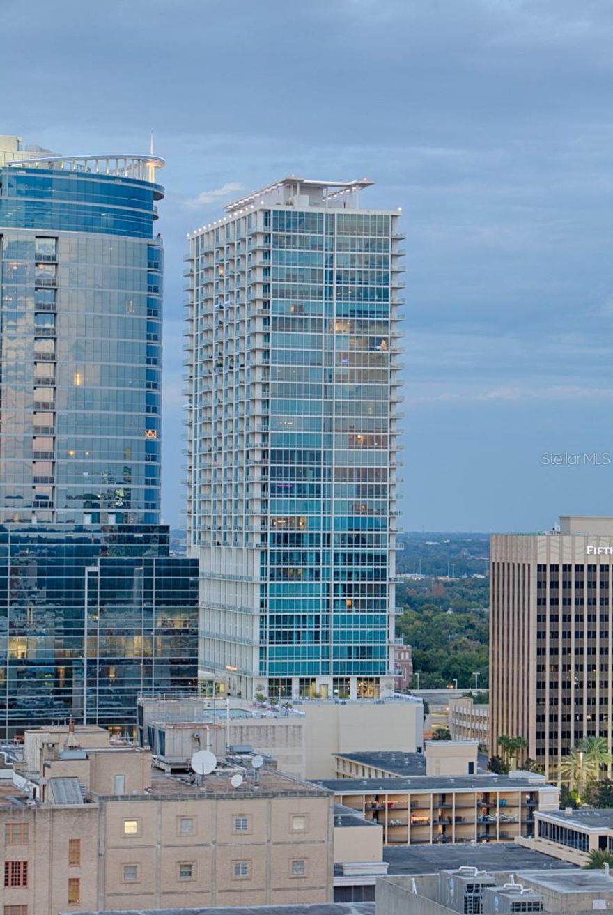 Welcome home to one of Orlando’s most desirable address. Located on the 4th floor of The VUE this former model home features exquisite lake views. This spacious unit has soaring 20 ft. ceilings and a two-story wall of windows overlooking the lake. There is also a large loft bedroom with a walk-in closet, light maple hardwood flooring, and an open kitchen with custom cabinetry, rich granite countertops and top of the line stainless steel appliances. With its own private terrace and floor to ceiling windows that flood the unit with natural light you can’t help but fall in love with the incredible views. The VUE is truly the personification of luxury urban living, from the 24 hour doorman to the concierge services and state of the art biometric finger print access. Owners will immediately feel a level comfort, serenity, and security. The building also includes unparalleled amenities like a Jr. Olympic size pool, tennis courts, theater, dog walk, Cyber Cafe / Lounge, meeting facilities, and a cutting edge health club. All of this just a short walk from some of the city’s most amazing dining and night life or a tranquil walk around Lake Eola to the Sunday morning farmers market.