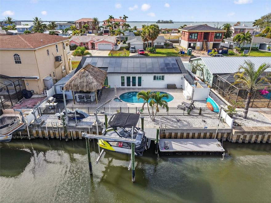 Welcome to Dunedin waterfront living!!! A thoughtfully upgraded waterfront home designed for both everyday comfort and effortless entertaining. From the moment you arrive, the extensive improvements stand out, including a new roof (2022), average impact-rated windows and doors (2022), new driveway, pavers with parking for 6 cars, and a long list of stylish interior updates. Inside, hardwood floors, plantation shutters, custom closets, new interior doors (2025), a beautifully renovated kitchen, updated bath, and a striking custom barn wood island create a warm yet refined feel. Outdoors, the lifestyle truly shines with a freshly refinished pool, electric heater (2025) & saltwater pool, tiki bar, or can be used as an outdoor kitchen, with a wet bar ! Fenced yard, and a private air-conditioned office beneath the tiki almost 100 sq feet, or your very own SHE-SHED! For boating enthusiasts, this property is exceptionally well-equipped with a seawall, 2019 dock and lift, 13,000 lb boat lift, floating dock, davits, and swing lift. A rare opportunity to enjoy updated waterfront living with the amenities to match.