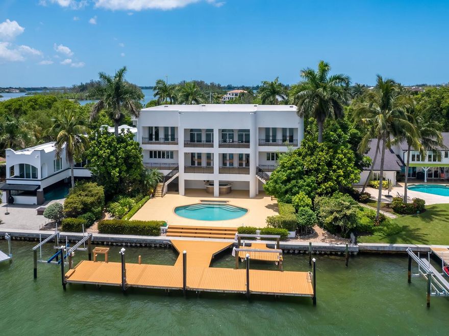 $1 million price reduction! Welcome to Casa Bianca, a spectacular Siesta Key bayfront estate offering breathtaking views and deepwater boating minutes to the Gulf of Mexico and Sarasota Bay. This is a rare opportunity to own one of the most iconic properties in Sarasota with positioned on Big Pass. Nestled behind a privacy wall and surrounded by spectacular, colorful gardens, this waterfront oasis offers a serene retreat. By day and night, savor the stunning skyline views of the Ringling Bridge, Bird Key, Lido Key, and downtown Sarasota across the bay. This 18,250-square-foot property is located on Bay Island, the gateway to Siesta Key, on one of Sarasota's most coveted streets. The first living level is elevated nearly 18 feet; the residence boasts panoramic water views from nearly every room. The spacious, open floor plan features soaring ceilings, seamlessly flowing from the bayfront gathering area to the kitchen, dining room, and family room. Entertain guests in style with a full custom bar. The private office is equipped with a desk and built-ins, perfect for the busy executive working from home. Large, covered terraces on two levels provide ideal spaces for entertaining, dining al fresco, or relaxing. Marble floors and custom railings enhance the luxurious ambiance of this special residence. Access the upper level via a gracious staircase or the three-stop elevator to the expansive primary suite, offering breathtaking views, a dressing room, and a sumptuous bath. Three additional bedroom suites with full baths ensure privacy for overnight guests. The expansive pool area epitomizes outdoor living. Quick, deepwater access to the Gulf of Mexico and Sarasota Bay. The 1,100-square-foot garage provides abundant space for vehicles and storage. The property offers endless opportunities for connecting with nature through boating, paddle boarding, snorkeling, windsurfing, and fishing, all from your private oasis. Discover dolphins, manatees, and an array of fish and waterfowl. In the evening, savor colorful sunsets and sparkling views of downtown Sarasota, Lido Key, and Bird Key. Arguably one of the best locations on the island and in all of Sarasota, this highly desirable North Siesta Key location is minutes away from the world-famous powdery white sands of Siesta Key Beach and the crystal azure waters of Siesta Key. The quaint shops and alfresco dining spots of Siesta Village are just minutes away, while the vibrant allure of downtown Sarasota is just across the north bridge. Considered the cultural gem of Florida’s west coast, Sarasota offers abundant urban, cultural, and social activities, including fine dining, a world-renowned art museum, galleries, ballet, symphony, opera, theater, and numerous charitable events. Convenient to Sarasota Bradenton International Airport, private aviation, and multiple golf courses, with easy access to Tampa, Naples, and Miami, Casa Bianca represents the epitome of luxury waterfront living. The dock shown in photos was damaged in hurricane Milton and will not be replaced.