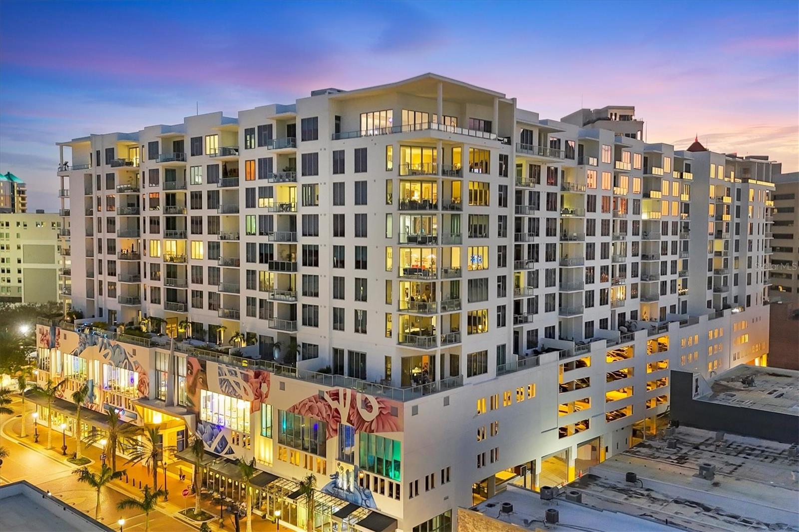 Lowest priced unit that offers 2 deeded parking spaces. Looking for luxurious urban living in a vibrant coastal city with space for 2 vehicles? This is your place! Positioned in the heart of downtown Sarasota, this residence at The Mark offers refined living with convenient access to everything people love about this city. Each day you’ll be reminded of your ideal location as you sit on your terrace watching the sun rise over the brick-paved city streets and your long views down palm-lined State St. In the evening you’ll enjoy the city lights on people strolling between the restaurants and boutiques more than 100 feet below. Step inside residence #804 and be welcomed by the clean, bright environment with abundant natural light flowing through the floor-to-ceiling sliding glass doors and windows, tall ceilings maximizing the feeling of space, and white, large-format porcelain tile providing a base for these ethereal environs. Custom finishes and a contemporary floor plan will impress discerning buyers. The kitchen features Euro-style cabinetry, JennAir appliances including an induction range/convection oven, pantry with pullout drawers, large island to accommodate four settings and elegant lighting making it inviting to guests and chefs. The two large bedroom ensuites are positioned at opposite ends of the residence providing maximum privacy. In the primary suite you are welcomed by views through the floor-to-ceiling wall of glass and sliders leading to the outdoor terrace, all of which are custom fitted with remote-control shades. A large walk-in closet and expansive hall closet make organizing your personal effects easy. The primary bath area is adorned with porcelain tile, white surfaces, dual vanities, upgraded fixtures and a large glass walk-in shower and water closet. On the other side of the residence is the guest suite awash in natural light. Custom remote control shades provide privacy here as well. The private bath area features a tub/shower combination for those who prefer the option. At the other corner of the residence is a den/study area often used as an office, theater or extra guest room. This residence also includes a laundry room with built-in cabinetry and an additional water closet adjacent to the kitchen serving as a powder room. Custom upgrades include designer light fixtures, tile backsplash in the kitchen, motorized Hunter Douglas shades with blackout versions in the bedrooms, large-format porcelain tile flooring, high baseboards, premium carpet in bedrooms, custom closet built-ins and surge protection. For your convenience a locked storage space is just a few feet down the hall. This is the first time this residence has been available. And, perhaps as a testament to its desirability, no unit in this stack has ever been resold since new - people hold on to these. The Mark provides 24-hour on-site concierge and security services. Its resort-style amenities are extensive: infinity lap pool and spa, expansive deck with cabanas, fire pits, outdoor kitchen/grilling area, lounge with fireplace, fitness center, community room with catering kitchen and bar for hosting events, and a conference room with high-speed internet for videoconferencing. Here at home, you’re close to it all: arts and entertainment, dining and shopping, even the bayfront. Come see why this property truly represents the epitome of elevated coastal downtown living.