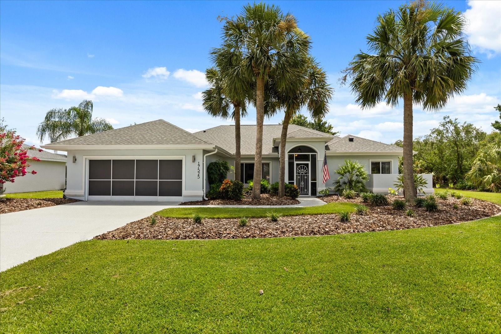 Discover the ultimate in privacy and comfort with a thoughtfully designed split floor plan in this exquisite Florida home. On a generous 1/3-acre corner lot, this three-bedroom, two-bath residence is surrounded by palm trees and lush landscaping, offering an ideal blend of style, comfort and outdoor living. Your private outside oasis is waiting for you, unwind by the resort-style oversized pool with heat pump for quick escalation to comfortable pool temperature on winter chilly nights and let's not forget about the soothing waterfall feature, all enclosed in a screened birdcage. A side door opens to a fenced area, ideal for pets, entertaining guests or relaxing. Inside, the remodeled primary suite is a retreat, showcasing new flooring, modern lighting, and a spa-inspired en-suite bath with double vanities, updated mirrors, a garden tub, a sleek new shower door, two walk-in closets and elegant features. The guest wing of the home features two spacious bedrooms and a beautifully updated second bath. Making it ideal for family or friends to visit. At the heart of the home is a gorgeous custom-designed kitchen featuring premium KitchenAid appliances, stylish cabinetry, a pantry and designer lighting. The cozy breakfast nook includes built-in cabinetry and a wine refrigerator, ideal for casual mornings or hosting brunches. Additional highlights include screened-in front porch for peaceful mornings. Expanded garage with interlocking non-slip flooring, large enough for two cars, golf cart and more, stainless utility sink, service door and a custom screen garage door for added functionality. Roof (2022), HVAC system (2018) and best of all, Shark Coating on the driveway, sidewalk and front porch for peace of mind. This home is the epitome of Florida living—don’t miss your chance to make it yours!