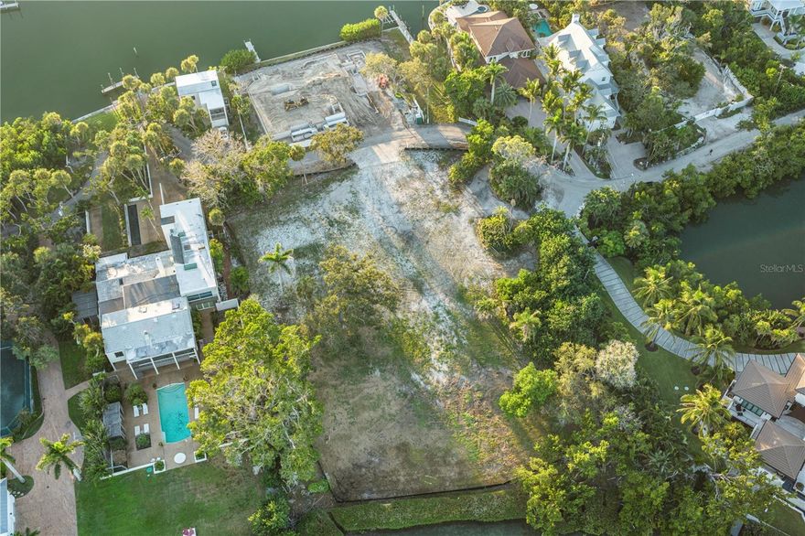 Exquisite Bay Island Estate Parcel Available. Build your dream waterfront estate on this exceptional 1.52-acre bayfront estate lot, offering both open bay access and a protected deep-water slip on Hansen Bayou. The east side of this extremely private lot boasts 212 feet of bayfront with expansive views to the East and South down the Bay. On the west side, is a large 54’ water front parcel with a seawall cut-out area allowing for a 50’ protected boat basin area with a private dock on deep water Hansen Bayou. Enjoy serene views of Edward’s Islands and Little Sarasota Bay, as well as stunning sunsets across Hansen Bayou to the west. The existing home is currently in the permitting process for demolition, allowing you to create a custom estate tailored to your vision. This one-of-a-kind opportunity will not last long. Due to hurricane damage the property is being sold “as is”.