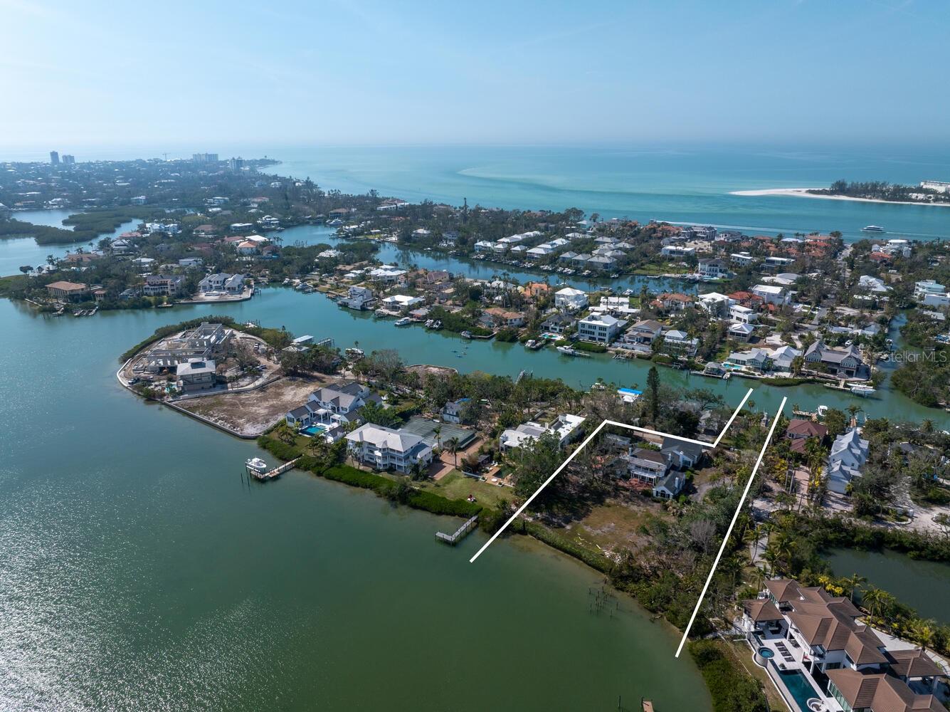 Exquisite Bay Island Estate Parcel Available. Build your dream waterfront estate on this exceptional 1.52-acre bayfront estate lot, offering both open bay access and a protected deep-water slip on Hansen Bayou. The east side of this extremely private lot boasts 212 feet of bayfront with expansive views to the East and South down the Bay. On the west side, is a large 54’ water front parcel with a seawall cut-out area allowing for a 50’ protected boat basin area with a private dock on deep water Hansen Bayou. Enjoy serene views of Edward’s Islands and Little Sarasota Bay, as well as stunning sunsets across Hansen Bayou to the west. The existing home is currently in the permitting process for demolition, allowing you to create a custom estate tailored to your vision. This one-of-a-kind opportunity will not last long. Due to hurricane damage the property is being sold “as is”.