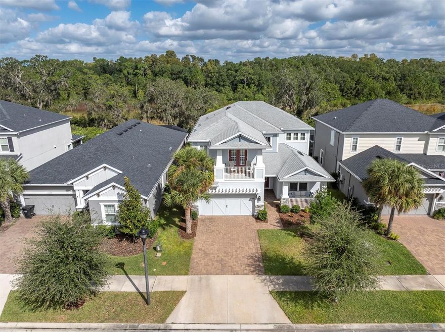 Welcome to 13709 Stansil Avenue, a stunning Taylor Morrison Barbados model nestled in the prestigious and vibrant community of Starkey Ranch. Designed for elegance, comfort, and flexibility, this expansive two-story home offers over 3,400 square feet of beautifully appointed living space backing to Starkey Wilderness Preserve on a coveted homesite with 5 bedrooms, 4 baths, and a dedicated office that the homeowners thoughtfully customized with French doors to create a private and functional workspace. Every inch of this home exudes thoughtful craftsmanship and timeless appeal. From the moment you arrive, the curb appeal is impressive, featuring a stately Craftsman elevation with an upper-level balcony, manicured landscaping, and an inviting front entry. Step inside and you’ll be welcomed by soaring ceilings, abundant natural light, and a perfect balance of open-concept flow and defined spaces. The homeowners reimagined the floor plan to provide both elegance and versatility, creating a separate office off the foyer adjacent to the formal dining room for those who work or study from home without sacrificing entertaining space. The heart of the home is the gourmet kitchen, designed for both culinary inspiration and gathering. It features stone counters, upgraded cabinetry, a gas cooktop, a built-in wall oven, a microwave, and stainless steel appliances. The large center island offers generous seating and workspace, complemented by a stylish backsplash and designer lighting. The open floor plan seamlessly connects to the great room, where high ceilings, recessed lighting, and views of the screened lanai, endless nature, and backyard create a warm and inviting atmosphere. The main floor also features a full bedroom and bath that functions perfectly as a guest or in-law suite, offering comfort and privacy for visitors. Upstairs, a spacious bonus room provides endless possibilities, from a media lounge or playroom to a secondary living space for relaxing or entertaining. The primary suite is a peaceful retreat with abundant natural light, and a spa-inspired bath that includes dual vanities, a soaking tub, and an oversized walk-in shower. Two walk-in closets have been designed for maximum organization and space. Secondary bedrooms are generously sized, two with a convenient Jack-and-Jill bath and an additional full bath next to the fourth upper bedroom, ensuring comfort for everyone. Step outside to your private backyard oasis, where you can unwind under the extended screened covered lanai or create your dream outdoor space perfect for a pool, garden, or summer kitchen. This home includes desirable upgrades such as elegant flooring, upgraded baseboards, stylish fixtures, built-in entertainment walls, and neutral designer paint tones throughout. The attached two-car garage offers ample space for vehicles, storage, and hobbies. Smart features such as UV lights on both ACs, reclaimed water, energy-efficient windows, hurricane shutters, whole-home saltless water filtration and softening system, water filter at the kitchen sink, and washer and dryer included. Residents enjoy multiple pools, playgrounds, dog parks, 22 miles of walking and biking trails, a K-8 school, library, community gardens, sports fields, and year-round events hosted by a dedicated activities director. Minutes from shopping, dining, medical facilities, and the Suncoast Parkway, Tampa International Airport and the beautiful Gulf Coast beaches. bit.ly/13709Stansil