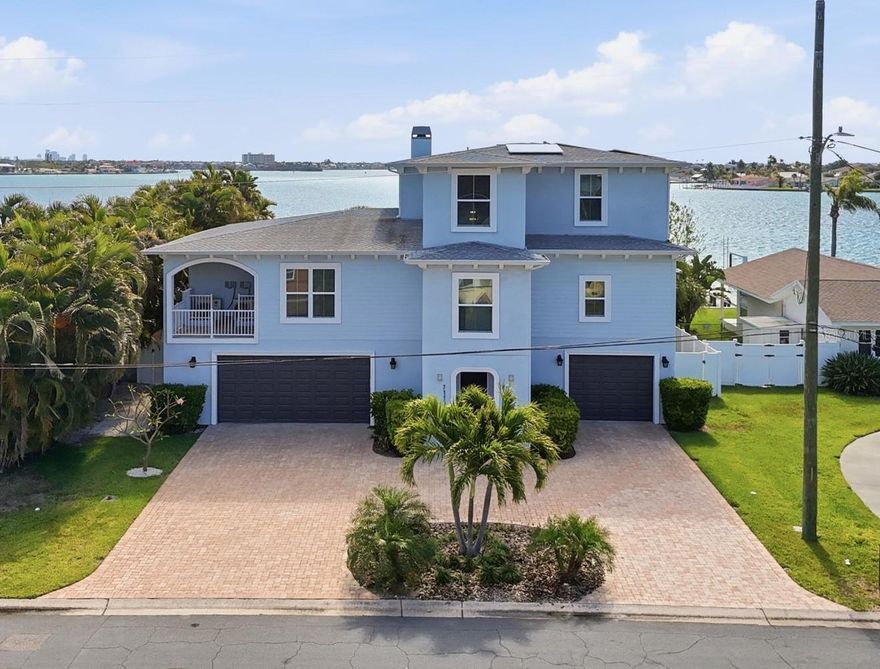 A rare waterfront estate on the wide-open intracoastal of Boca Ciega Bay—designed for those who value exceptional quality, space, privacy, and effortless Gulf access without compromise. Completed in December 2018, this luxurious, meticulously maintained 3-story home sits on an oversized 75-foot deep-water lot and delivers unobstructed water views. The morning sunrises are spectacular, and in the distance you can see downtown St Pete and Gulfport. Boaters will love the 72-foot Trex DOCK (water and electric ready), while beach lovers will enjoy the short walk to Upham Beach. The 2nd story main living level offers panoramic water views, over 500 square feet of covered balcony space, and an open layout that connects living, dining, and kitchen without interruption. A wood-burning FIREPLACE, WET BAR, and full wall of impact-rated sliding glass doors create a dreamy setting for entertaining or quiet evenings overlooking the bay. The kitchen is built for function and scale: solid wood custom cabinetry, DOUBLE OVENS, a 5-burner cooktop (2025), expansive island seating, and a fully outfitted walk-in pantry and laundry space. The primary suite is intentionally private and SOUND INSULATED—featuring water views, a freestanding jetted tub positioned at the window, dual marble vanities, an oversized shower with bench seat, and a custom walk-in chandeliered closet that exceeds expectations. Additional bedrooms, including a secondary suite, carry the same level of finish, spaciousness and elevated design. Outside, the luxury resort style living experience continues with a SALTWATER POOL, a covered lanai, and lush tropical landscaping providing privacy on either side of the nearly quarter acre lot. Performance and efficiency set this home apart: SOLAR panels (LOW ELECTRIC BILLS from $36/month), STEEL & insulated construction, ELEVATOR, whole-home WATER SYSTEM, GENERATOR switch, and an oversized 4-car garage with oversized doors, tons of extra storage and working space, and EV charging. FLOOD INSURANCE is assumable at just $620/year. From this location you can walk to many local shopping, dining. and entertainment options, including Corey Avenue with its famous Sunday Market and Horan Park's free concerts in the park. Schedule your showing today.