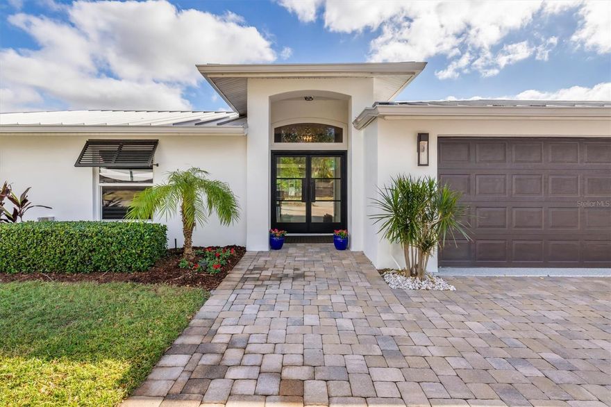 One or more photo(s) has been virtually staged. Tucked away in a quiet mainland neighborhood near the south bridge to Siesta Key you will find this remarkable customized waterfront home. Nearly every aspect of this home has been rethought and reimagined with over $500,000 in upgrades that took place in 2015 and again in 2023. This site took no damage from the recent storms, a testament to the location and quality of the build.! At the entry of this home, you will notice hurricane-rated custom iron doors, designer porcelain blond wood-look flooring throughout, PGT hurricane impact rated windows and sliders, and the maintenance free standing seam metal roof. The open and thoughtful floor plan offers an idyllic waterfront retreat and has upgrades such as solid-core interior doors, recessed LED lights, custom window treatments, and highly detailed architectural trim work. The primary bedroom suite is a work of art- enjoy natural light and water views while relishing a spacious bathroom suite that rivals the finest resorts. Luxury features of the primary suite include a free-standing soaking tub, designer mother-of-pearl tile, Brizo fixtures, on-demand water heater, and oversized walk-in closet. Second primary suite includes a private entrance, ensuite bathroom and sitting area, ensuring  comfort and privacy for visitors. The great room features open views of the pool deck and canal as well as intricate ceiling woodwork, 60 inch linear electric fireplace, and Camacho designer marble look fireplace décor. The kitchen features stainless steel appliances, built-in Fisher and Paykel refrigerator with custom designed solid wood cabinets, and a walk-in pantry. The oversized pool deck gives plenty of room for outdoor enjoyment and the pool features electric heat and is saltwater. The fenced-in backyard gives way to a 10' x 34' dock that has a new raised seawall, vinyl panels, and cap as well as a 10,000 lb boat lift and stainless steel ladder. It is hard to express all the meticulous upgrading and updating in this fine home, and the location is second to none. Perfectly positioned on a premium deep water canal front lot, the intracoastal waterway is within minutes and no bridges. No HOAs. Indulge in the waterfront lifestyle you've been dreaming of and schedule your private showing today!