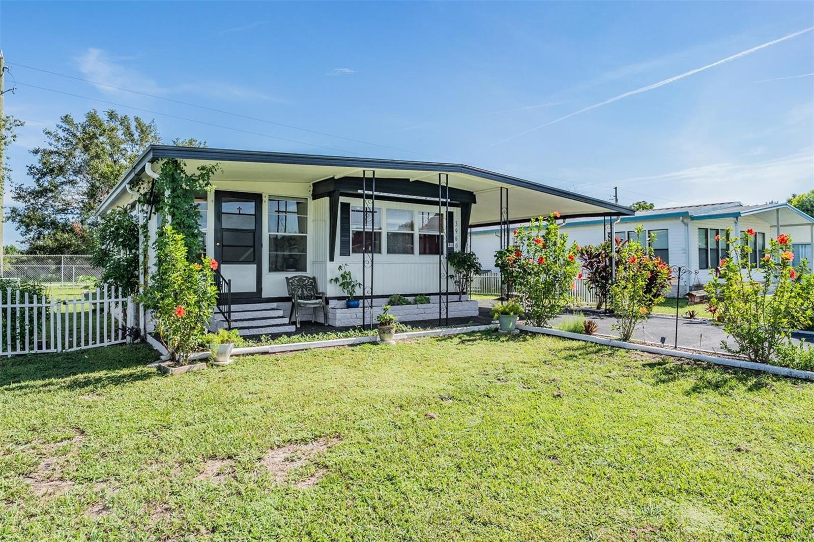 Welcome to this cozy but spacious home that comes FULLY FURNISHED with LOADS OF UPDATES!! Kitchen has newer raw wood cabinets w/ original hardware (2022), Custom tiled countertops (2022), New Electrical outlets (2022), New drywall (2023), Most windows have been replaced (2023), New Stove and Microwave (2023), New Water Heater (2023), New complete fenced in yard (2023), New Exterior Paint (2022), Brand New Epoxy finished drive & walkway (August 2025), All appliances stay including, Refrigerator, Stove,Microwave & Stackable Washer & Dryer. Primary bedroom has built in desk & drawers. The Tandem style Carport can easily house 3-4 Cars , also has an outdoor Storage/Workshop area. ONLY $350 Annual HOA Dues. PETS ARE WELCOME!! GEM ESTATES is unique to itself with parcel ownership, very spacious lots and is close to shopping and restaurants but also tucked away from the city hustle & bustle. Start packing..this one will not be on the market long!!