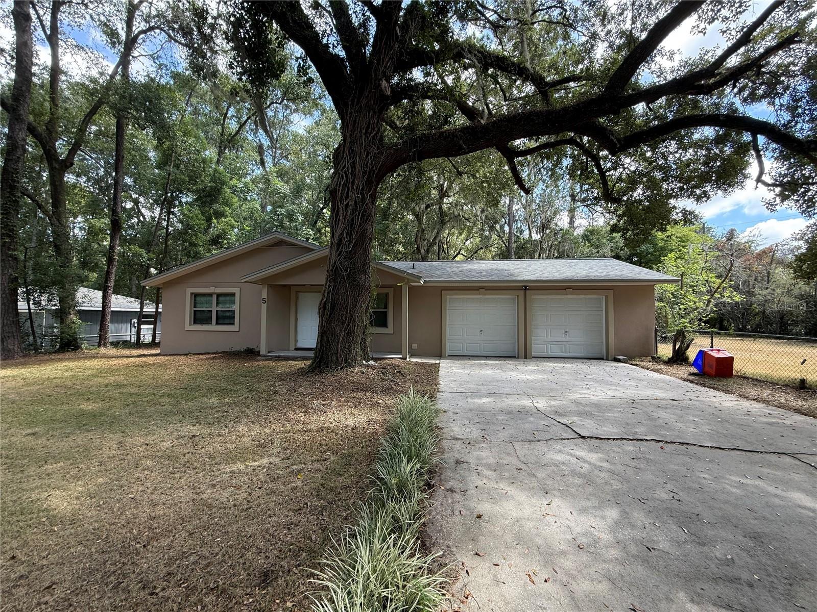 Welcome to this beautifully maintained single-story home nestled on a shaded lot in a nice, tree-lined neighborhood. Offering 3 bedrooms, 2 full bathrooms, and close to 1,500 sq ft of living space, this home blends comfort and functionality with room to spread out.
The bright and airy kitchen features updated appliances, ample cabinet space, and a breakfast bar overlooking a large, tiled family room with a cozy stone fireplace — perfect for relaxing or entertaining. Enjoy the convenience of a dedicated laundry space in the oversized two-car garage.
The home features two updated bathrooms, including one with a walk-in tile shower and the other with a double vanity and tub/shower combo. All bedrooms are spacious with wood-look flooring throughout — no carpet!
Step outside to a large, screened-in back patio ideal for outdoor dining or relaxing bug-free. The backyard offers privacy, mature trees, and plenty of space for pets or play.