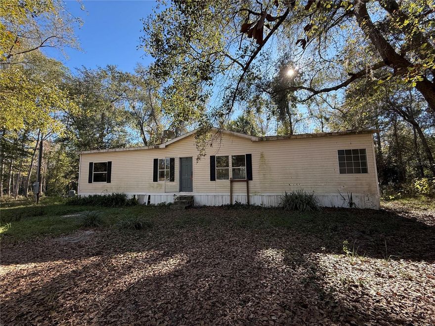 Tucked away off a private limerock road, this inviting property offers peaceful seclusion without sacrificing convenience. Set on 2.22 acres of serene countryside, this 3-bedroom, 2-bath manufactured home—built in 2008—provides comfort, efficiency, and room to grow in a quiet rural setting. With 1,456 square feet of living space, the home features a desirable split floor plan designed for both privacy and functionality. The spacious living room flows seamlessly into the dining area and large open kitchen, making it ideal for everyday living and entertaining. The primary suite serves as a private retreat, complete with ample space, a large walk-in closet, and an en-suite bath. Two additional well-sized bedrooms share a second full bathroom. Wood and tile flooring throughout the main living areas and bathrooms have durability and easy maintenance. Zoned AG (Agricultural), the property allows for a variety of uses and lifestyle possibilities. Enjoy the best of North Central Florida living with easy access to Gainesville, Ocala, and Palatka. Nearby towns such as Melrose and Hawthorne provide charming arts, dining, and recreational options. With no HOA, low taxes, and endless potential, this property is perfect as a primary residence, weekend getaway, or income-producing investment.