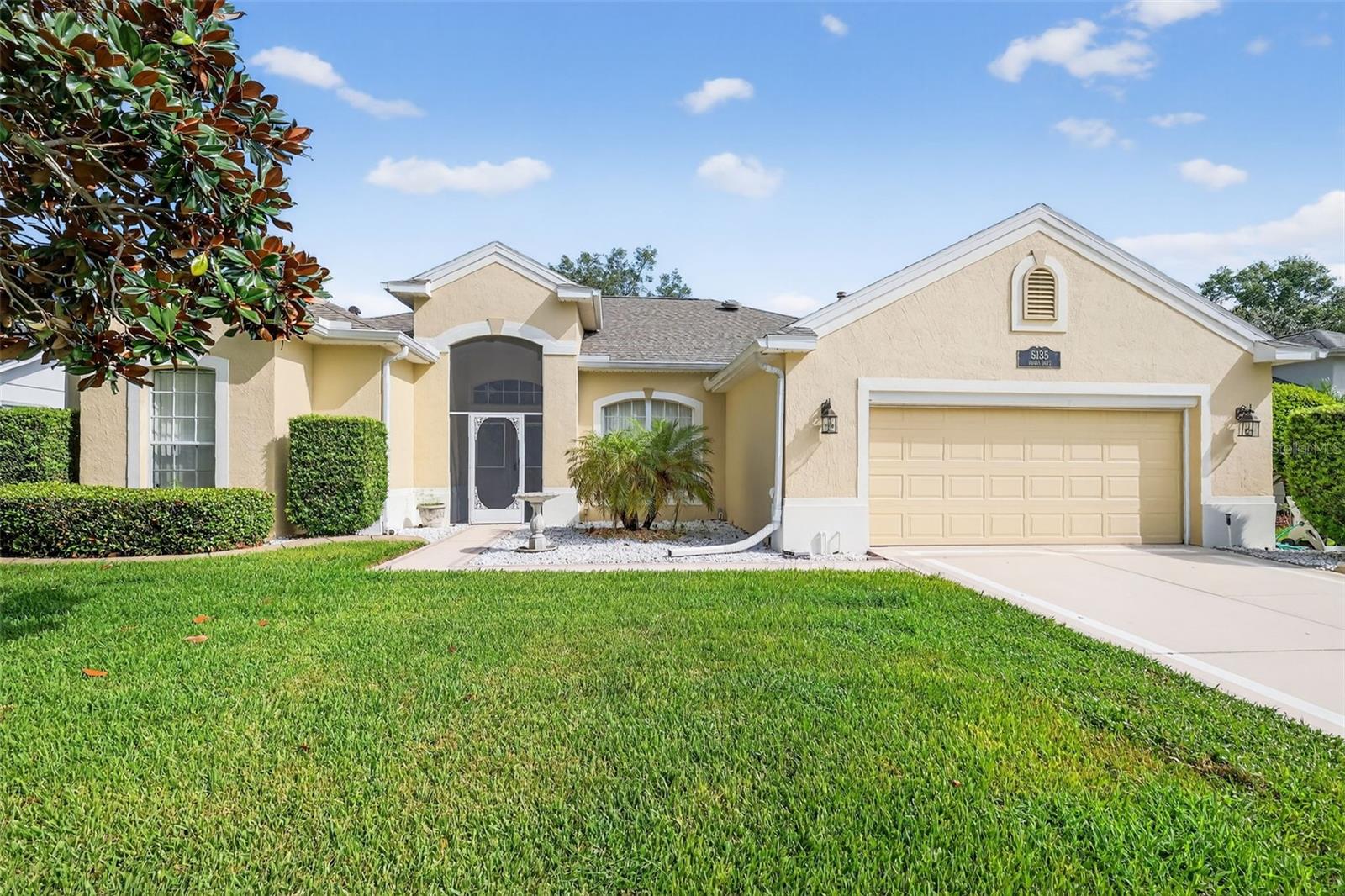 Amazingly nice custom Savannah/Scarsborough model in desirable Legacy of Leesburg. This immaculately kept home is truly "like new" with beautiful features everywhere! Leaded glass double door entry, vaulted ceilings, expanded interior and garage space, enclosed lanai with large clear windows that provides lots of light. Triple sliding doors highlight the handsome living room and also the ceramic tiled family room. Tasteful gourmet kitchen features oak 42" cabinetry, closet pantry and amazing walk-in custom storage area, appliances, plus washer/dryer. Besides the large family room, breakfast nook, and living room, there's also a formal dining area. This split plan home features a beautiful master suite with many windows and private sliding doors to lanai, two expansive walk-in closets, and designer custom bath that houses a jetted tub, walk-in "Roman" shower, both with custom tilework and pretty listello trim. Dual sink vanity is also oak. Your guests will be comfortable in two private, expanded bedrooms and adjacent spa bath. The garage has been improved by added sq. ft., side utility door, laundry with sink and separate a/c. Enjoy an active lifestyle here! All of this in upscale Legacy, home to miles of walking/biking trails and acres devoted to wildlife conservation. Full complement of amenities includes designer heated pool/spa, fitness and so much more. Low HOA includes mowing, cable and all the fun, just waiting for you to enjoy this quiet peaceful retreat. (New Roof in 2020, AC in 2018)
Come home to Leesburg, Florida!!