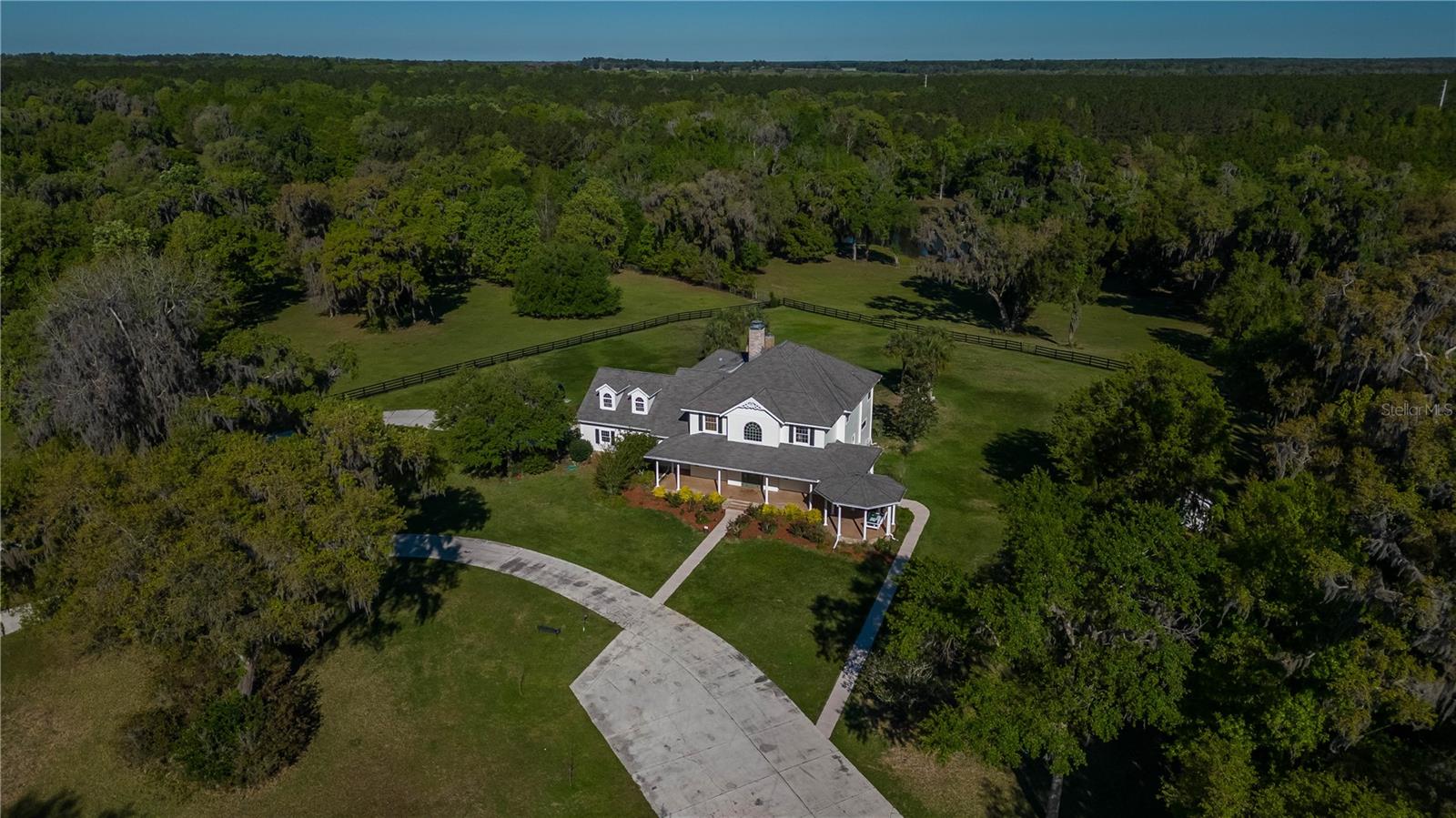 Under contract-accepting backup offers. UNDER CONTRACT, BACK UP OFFER IS ACCEPTED! Welcome to an extraordinary equestrian paradise – a turn-key horse farm nestled within the picturesque beauty of 150 acres, just a short 25-minute drive from the World Equestrian Center, Ocala, and Gainesville. This incredible property, located a mere 5 minutes from the historic Ocala Jockey Club and as plans unfold for the Ocala Jockey Club's transformation, this property stands as a gateway to the future of premier equestrian entertainment. The potential for increased property value, enhanced equestrian amenities, and a vibrant equestrian lifestyle make this location highly desirable for those with a keen interest in the equestrian world.
As you enter through the grand electric gate, a paved tree-lined driveway welcomes you to the heart of this elite estate. The property boasts 7 paddocks, each equipped with auto water units, 26 sorting pens spread across three paddocks, and an 80'x160' arena surrounded by PVC fencing. The horse facilities further include a center-aisle, 7-stall barn with an air-conditioned tack room and wash racks, all enclosed within fence-lined pastures.
Perched upon the rolling hills of horse country, the one-of-a-kind modern Victorian-inspired custom estate spans 4809 sqft. This meticulously designed home features a 50-year luxury laminate shingles roofing, ensuring both durability and timeless elegance. The interior is adorned with attention to detail and upgrades, offering four en-suite bedrooms, two additional half-baths, a built-in office, a bonus room, and a two-car garage converted into a gym with seamless epoxy flooring and a newly installed AC.
A transom front door welcomes you into the two-story foyer and grand staircase, leading to a private retreat in the form of the Master Suite. This sanctuary boasts spectacular views, a fireplace, a sitting area, and double French doors opening to a serene lanai overlooking the lush green backyard. The Master Suite also includes a spacious walk-in closet with its own washer/dryer and a spa-like bathroom.
Recent renovations add to the allure of this estate, including a fountain/aeration system in the front pond, new fencing, and a large raised garden. Approximately 80 acres of the property are adorned with pine trees, poised for harvest in the coming years.
This property is not only a haven for horse enthusiasts but caters to the needs of cattle ranchers and individuals of various equestrian disciplines. The farm combines a convenient location, a private setting, exquisite design, and southern charm, making it stand out from other properties in the area. This is a once-in-a-lifetime opportunity to own a truly amazing turn-key farm – an idyllic blend of luxury and functionality, perfectly tailored to satisfy all your equestrian needs. Don't miss the chance to make this extraordinary estate your own.