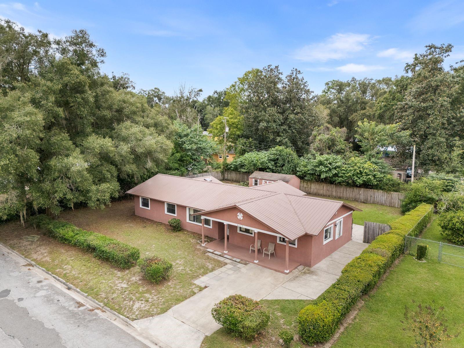 One or more photo(s) has been virtually staged. Here’s the home you’ve been waiting for! Solid concrete block construction with a 2018 metal roof and brand-new water heater, ideally located near Gainesville’s Premier Park-- the Morningside Nature Center — 416 acres of preserved Florida beauty with trails, wildflowers, and wildlife!
You’ll love the convenience — close to schools, University of Florida, and major hospitals. The versatile layout offers amazing possibilities! Featuring 3 bedrooms, 2 baths, a den/office/flex room (which was the original living room), plus a spacious great room addition that could potentially be enclosed for a private in-law suite/guest suite or rental. This area already includes its own entrance, a walk-in closet that is next to the laundry room. (There's enough space to keep the laundry room separate and shared by both spaces). Freshly painted in parts and professionally cleaned, this home is move-in ready. The updated kitchen has newer cabinetry and granite countertops, while the hall bath features a modern vanity. You’ll find tile floors in the kitchen and flex areas and laminate floors in the great room. From the dining room, go through French doors with side lights and blinds inserts and step out to the huge screened porch for peaceful afternoons, or enjoy the fenced backyard complete with a large storage shed — perfect for tools and hobbies. Great sized yard and plenty of extended concrete pads for parking and extra patios. So much potential, so much value! Call today before this gem is gone.