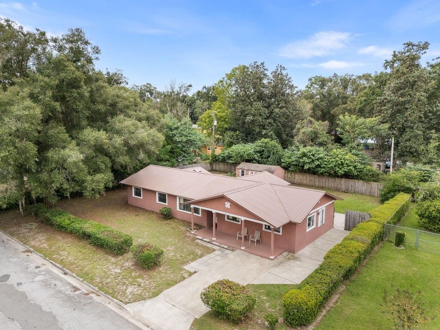 One or more photo(s) has been virtually staged. Here’s the home you’ve been waiting for! Solid concrete block construction with a 2018 metal roof and brand-new water heater, ideally located near Gainesville’s Premier Park-- the Morningside Nature Center — 416 acres of preserved Florida beauty with trails, wildflowers, and wildlife!
You’ll love the convenience — close to schools, University of Florida, and major hospitals. The versatile layout offers amazing possibilities! Featuring 3 bedrooms, 2 baths, a den/office/flex room (which was the original living room), plus a spacious great room addition that could potentially be enclosed for a private in-law suite/guest suite or rental. This area already includes its own entrance, a walk-in closet that is next to the laundry room. (There's enough space to keep the laundry room separate and shared by both spaces). Freshly painted in parts and professionally cleaned, this home is move-in ready. The updated kitchen has newer cabinetry and granite countertops, while the hall bath features a modern vanity. You’ll find tile floors in the kitchen and flex areas and laminate floors in the great room. From the dining room, go through French doors with side lights and blinds inserts and step out to the huge screened porch for peaceful afternoons, or enjoy the fenced backyard complete with a large storage shed — perfect for tools and hobbies. Great sized yard and plenty of extended concrete pads for parking and extra patios. So much potential, so much value! Call today before this gem is gone.