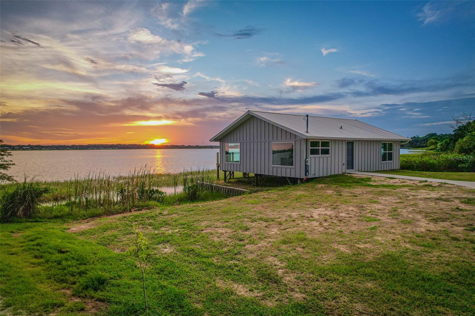 One or more photo(s) has been virtually staged. Welcome to your dream lakefront home on the pristine shores of Lake Juliana in Auburndale, Florida! This newly renovated 2-bedroom, 2-bathroom retreat offers 1,200 square feet of modern luxury, paired with incredible panoramic water views.
Step inside to an open-concept living area with large picture windows that frame the sparkling lake and fill the home with natural light. The chef-inspired kitchen features sleek quartz countertops, stainless steel appliances, custom cabinetry, and an oversized island perfect for entertaining or casual dining. The spacious living and dining area flows seamlessly, making it ideal for gatherings with family and friends.
Both bedrooms are designed for comfort, with generous closet space and serene views. The spa-like bathrooms boast stylish vanities, contemporary tile work, and walk-in glass showers for a touch of luxury.
Enjoy your morning coffee or evening glass of wine on the expansive deck overlooking the water, where unforgettable sunsets paint the sky. The property’s prime lakefront location is perfect for fishing, kayaking, or simply relaxing and taking in the beauty of nature.
Whether you’re looking for a full-time residence, a vacation getaway, or an investment property, this home offers it all—modern upgrades, tranquil surroundings, and direct access to one of Central Florida’s most desirable lakes.