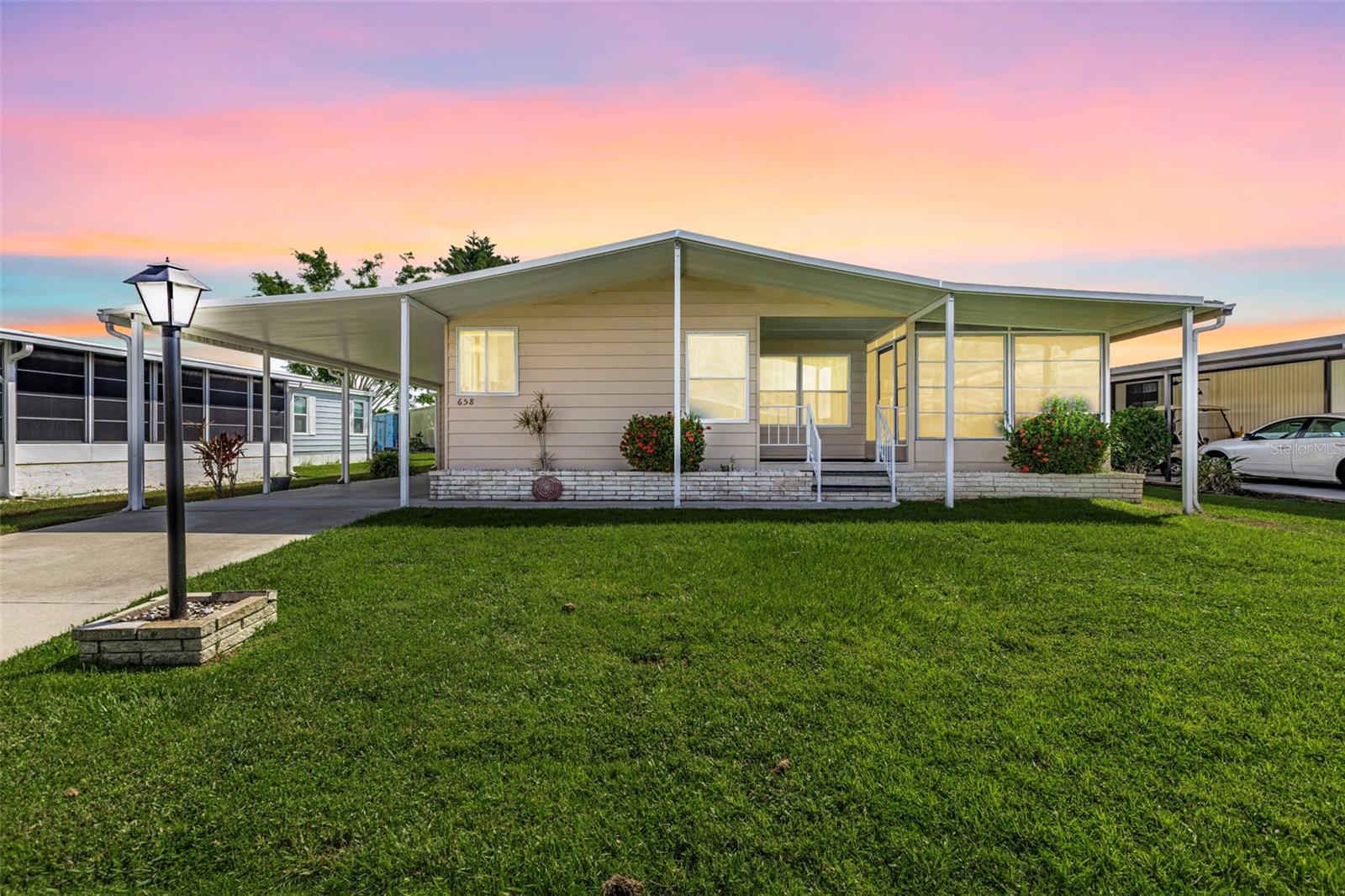 This lovely two-bedroom, two-bath home is situated on a quiet street in La Casa. The kitchen features an entryway with a built-in desk, a center island, newer cabinets, a storage cubby, and modern appliances. You can enjoy your morning coffee in the corner breakfast nook while taking in the street views. The dining room includes a built-in hutch, perfect for storing your China and special belongings. Sliding doors from the living room lead to a vinyl-enclosed Florida room, which also has a door to the covered front porch. The primary bedroom boasts a dressing area with a new vanity, a marble countertop, two medicine chests, and a spacious walk-in closet. The primary bathroom includes a walk-in shower. The guest bedroom features a mirrored pocket door that opens to a large walk-in closet, while the guest bathroom has a vanity and a tub/shower combination. The home offers central A/C and ceiling fans, and a new Comfort Cover roof-over added in 2023. The extended carport leads to a utility room equipped with a workbench, storage, a washer, a dryer, and a deep sink.
La Casa boasts 974 homes nestled among a variety of native trees with spacious common grounds surrounding our eight lakes. Our lots average a generous 60' by 80'. La Casa, offering the ultimate lifestyle on Florida’s Gulf Coast, is located between Sarasota and Fort Myers. . It is convenient for shopping, sightseeing, golfing, fishing, and boating, as well as all the culture and elegance the Southwest Florida area is noted for. Residents and visitors enjoy the warmth of Southwest Florida winters in a relaxed and unhurried environment far removed from the hustle of Florida’s east coast. You’ll be surrounded by mature lush landscaping which demonstrates the utmost level of care our property receives from residents and management. Wireless Internet (Wi-Fi) is available at the Clubhouse, Activity Building, and Recreation Hall area where the pools & spas are located, so you can catch some rays while you catch up on your email! Sound enticing? La Casa is a friendly, family community. You will be away from the hustle and bustle except when you want to be part of it. Come for a visit to this self-contained oasis and see for yourself why La Casa is the ultimate destination for both snowbirds and year-round residents!