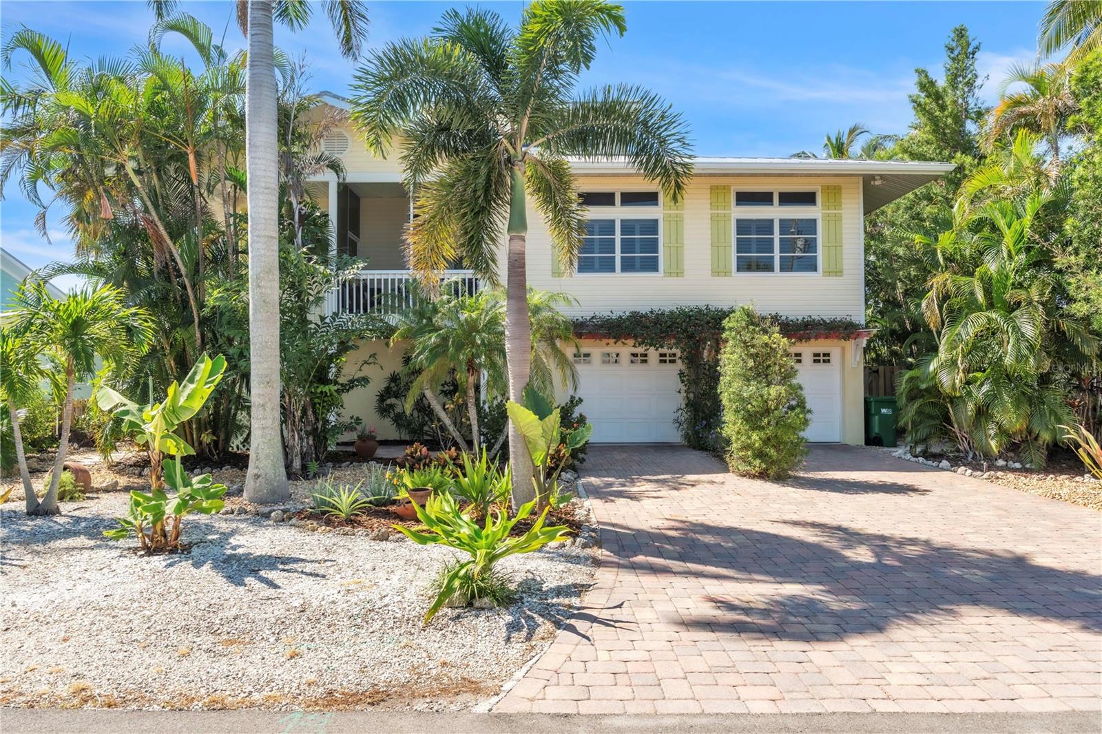 Surrounded by lush tropical beauty on the north end of Anna Maria Island, this lovingly maintained canal front home invites you to embrace island living with both style and ease. Just a short walk from the powder soft sands of the Gulf, the property is tucked among swaying palms and vibrant landscaping, creating an instant sense of retreat the moment you arrive. Inside, the open floor plan blends casual elegance with functionality, featuring a spacious living area with a tray ceiling, custom fans, and plenty of natural light that pours through large windows and sliding glass doors. The kitchen is designed for both beauty and performance, offering stainless steel appliances, granite countertops, a center island with cooktop, and crisp white cabinetry, all framed by peaceful green views through plantation shutters. Flowing seamlessly into a sun filled dining space and out to both front and back screened porches, the home’s layout encourages effortless indoor/outdoor living. The primary suite is a tranquil escape with private canal views, while the ensuite bath evokes a spa-like feel with dual sinks, a soaking tub, and walk-in shower. Two additional bedrooms each bring their own tropical charm, and a top level bonus room offers flexible space for a home office, media lounge, or guest accommodations. Step outside to your own private backyard paradise, where lush landscaping surrounds a sparkling pool, paver patio, and covered seating areas ideal for year-round enjoyment. And for those drawn to life on the water, the private dock with a boat lift is a true standout offering direct, easy access to the bay and Gulf, making boating, kayaking, or paddle boarding not just possible, but part of your daily rhythm. A spacious multi-car garage provides abundant room for storage, beach gear, bikes, and golf carts, making this home as practical as it is picturesque. Located in a short term rental zone and just minutes from Anna Maria’s beloved shops, eateries, and beaches, this home offers the ultimate blend of personal comfort and investment potential. Whether you're seeking a full-time residence or seasonal getaway, this island gem delivers on every front.