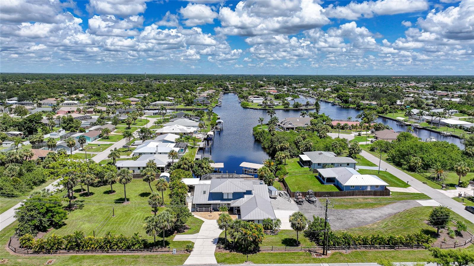 Rare waterfront gem on 1.17 acres with 100 feet of saltwater canal frontage, offering a quick 10–15 minute boat ride to open water from your private 55-foot dock with dual boat lifts. This expansive property stretches from block to block and is partially fenced, featuring a storage shed and plenty of space for all your extras, including an RV or camper with its own electrical hookup. The home sits perfectly centered on the property with two separate driveways providing dual access to the 4-car garage, offering convenience and versatility.
Inside, you are welcomed by a spacious layout with a foyer, formal living room and dining room. The updated kitchen sits at the heart of the home perfect for gatherings boasting tons of cabinet and counter space, positioned between a flexible sitting area and the cozy living room with a fireplace. Off the living space is a bonus room with panoramic canal views... bright, versatile space perfect for relaxing, entertaining, or creating a hobby room. The first floor features a split plan with the primary suite, family room, living room, formal dining, breakfast nook, one guest bedroom, and one full guest bathroom. The primary suite offers lanai access, dual closets, dual vanities, and a walk in shower for those who cherish their own personal space. Upstairs, an additional living area, two bedrooms one has dual closets, and a full bathroom create a private wing of the home, ideal for guests, or extended family to enjoy their own space. Outside, the views are breathtaking as you look straight down the canal from the screened paver pool deck. The sparkling blue salt water pool shares this incredible view, while the screened area includes a covered lanai for shaded relaxation. Beyond, a true cabana style porch with four ceiling fans provides a breezy, all weather spot perfect for hosting family and friends. At the dock, every detail has been considered, no detail missed. First lift accommodates up to 16,000 pounds, while the other is currently set up for multiple jet skis but can easily be converted for another boat while being covered from the sun. A fish cleaning station makes preparing your fresh catch a breeze. This home not only offers beauty and function but also peace of mind with hurricane windows throughout and never-used flood prevention barriers. Combining safety, practicality, and dreamy waterfront living, this property is also conveniently located near shopping, dining, beaches, and more. Call today to schedule your private tour.