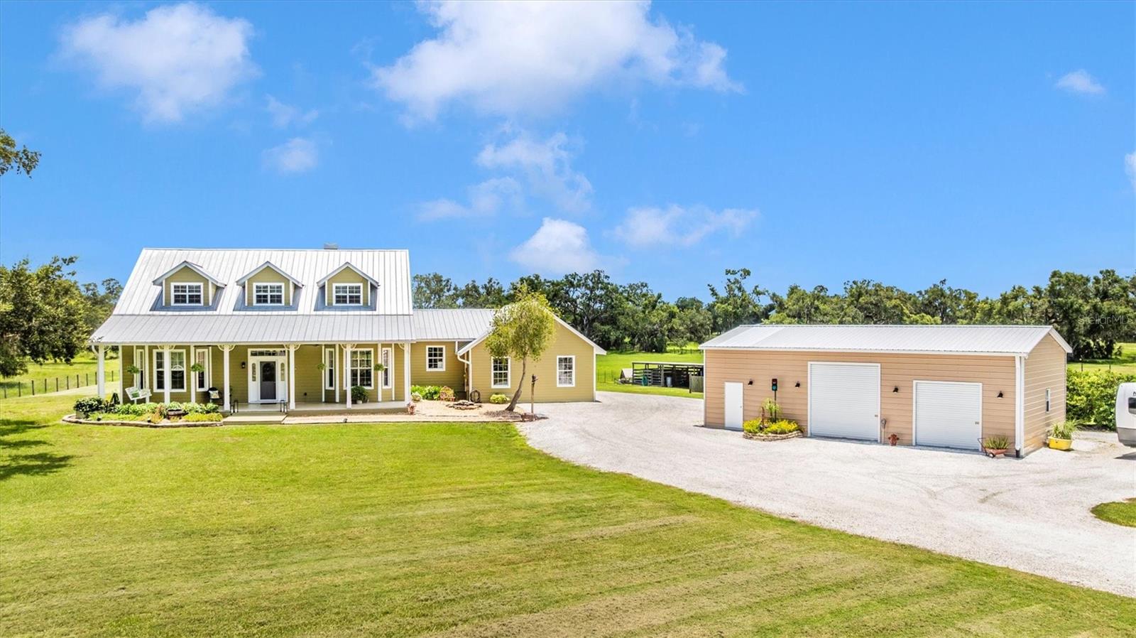 Welcome to your home in the COUNTRY on a neat. fresh shell driveway! This unique 3-bedroom, 2½-bathroom retreat is fenced on nearly five acres blends rustic charm with modern comfort. New Metal Roof 2020. Step inside to soaring high ceilings, Foyer with closet, Living Room that opens to screened porch and deck beyond with unobstructed view of your land. An upgraded kitchen also features unobstructed view of your land, room for a table, lots of cabinets and granite countertops. Main level Primary Bedroom with en-suite bathroom and walk-in closet, two bedrooms upstairs and a large landing space as a bonus room, perfect for a desk at the large window that overlooks your land. The floorplan creates a warm, inviting atmosphere for everyday living or entertaining.
Outdoors, an extra-large east-facing deck is perfectly positioned for tranquil mornings and maximum enjoyment of sunrise views across your acreage which is bordered by large oaks. See the deer and Sand Hill Cranes playing? In addition to an attached 3+ car garage, the property also includes an oversized detached garage with a large workshop with three roll-up doors and a vehicle lift—ideal for hobbyists or car enthusiasts. Landscaped Shell Parking for RV or boat. For equestrian or animal lovers, there’s a three-sided shed with two pens and two open stalls, all within a fully fenced property.
Picture yourself on the front porch swing, under ceiling fans, soaking up the peace and quiet of country living. This estate is nestled in a community with horse trails, offering both privacy and outdoor adventure.
Whether you’re seeking space for your passions, room for animals, or simply a serene lifestyle close to Sarasota, shopping, entertainment, dining, beaches, boat ramp, 1901 Joshua Drive delivers it all—land, lifestyle, and lasting value.