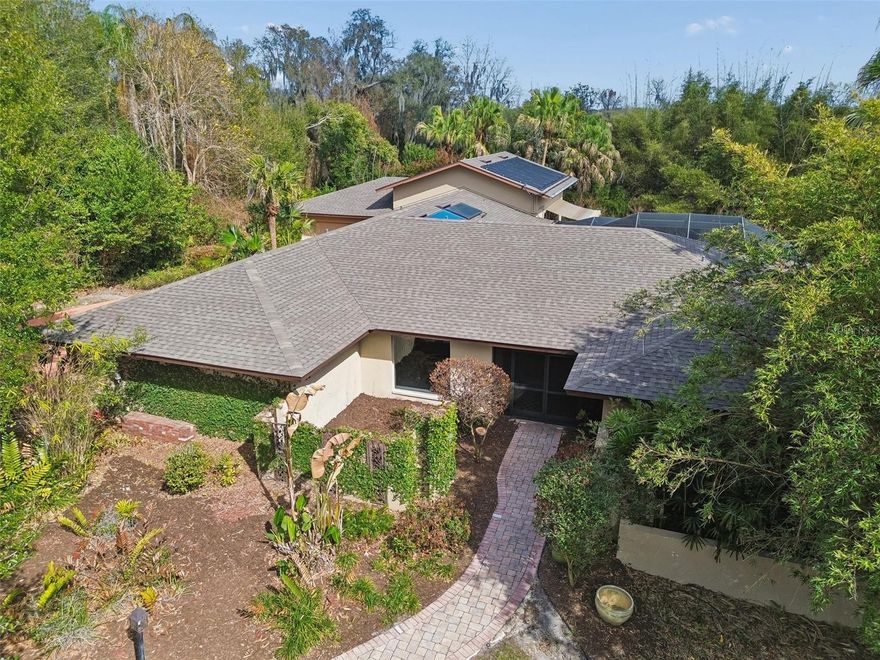 Exceptional four-bedroom, three-bathroom pool home located in one of South Lakeland's most sought-after neighborhoods, just one block from Scott Lake. The property features two double car garages and a lanai with a solar-heated pool, all situated on over an acre of mature, landscaped grounds. Upon entering through custom wood doors, you are welcomed into the foyer. To the left is a formal dining room with an elegant chandelier; plenty of additional natural light from the picture window. Straight ahead lies the formal living room, which opens to the lanai through French doors. Continuing to the right, the primary suite features an en-suite bathroom, spacious walk-in closet/dressing area, plus a spiral staircase leading to the hurricane room/ fun room, what a great safe place with access through French doors to the back yard.

Back in the main foyer proceeding left leads to the kitchen, well equipped with double ovens and custom wood cabinetry. A large “hidden” pantry will be the delight of any cook. Of course, granite counter tops complete the look, not forgetting the wet bar. The kitchen opens to the family room with plenty of space for the dinette and room for the family to enjoy. Through a convenient pocket door, we have two additional bedrooms and a bathroom with full tub. Off the family room there’s an additional bedroom and across the hall the pool bathroom with shower. Continuing down a couple of stairs, an expansive great room awaits, impressive with high ceilings and abundant natural light from numerous large windows, as well as direct access to the pool/lanai area and an electric awning for enhanced relaxation. The double level pool deck is where you will want to be, enjoying what this charming piece of paradise offers. The top deck has access to the main living areas as well as an outside bar.

The fenced backyard includes several spaces to enjoy the serene bamboo garden and a secluded shed with installed electricity. Properties in this neighborhood seldom become available, with the last sale occurring eight years ago. This offering represents a rare opportunity in South Lakeland.