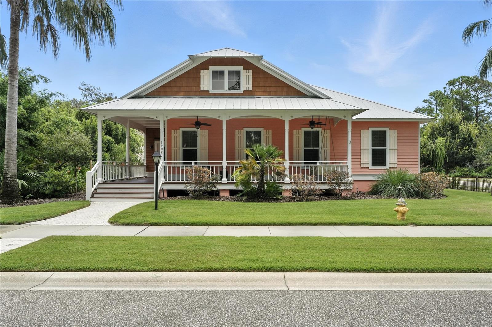Gorgeous, coastal chic 3 bdrm/ 2 bath home on a corner lot in the gated Hickson community of Florida Days. Fabulous one-of-a-kind touches throughout! Welcoming veranda complete w/ porch swing.  Lovely foyer entry w/ coral rock accent wall. Volume ceilings, custom millwork, plantation shutters, driftwood inspired flooring. Inviting family rm feat. wood detailed tray ceiling, gas fireplace, built-in bookshelves. Beautiful kitchen w/ tile backsplash, quartz countertops, neutral cabinetry, eat-in snack bar, gas stove & stainless appliances. Private & grand primary suite w/ walk in closet, luxurious bath w/ double vanity, tiled shower. Separate guest bdrm wing w/ dedicated study area and built in desk in the hall. Indoor laundry rm w/ sink, storage. Fantastic multi level patio, screened pool w/ shelf entry & seating & outdoor shower. Metal roof. 2 car garage. Old Florida charm awaits!