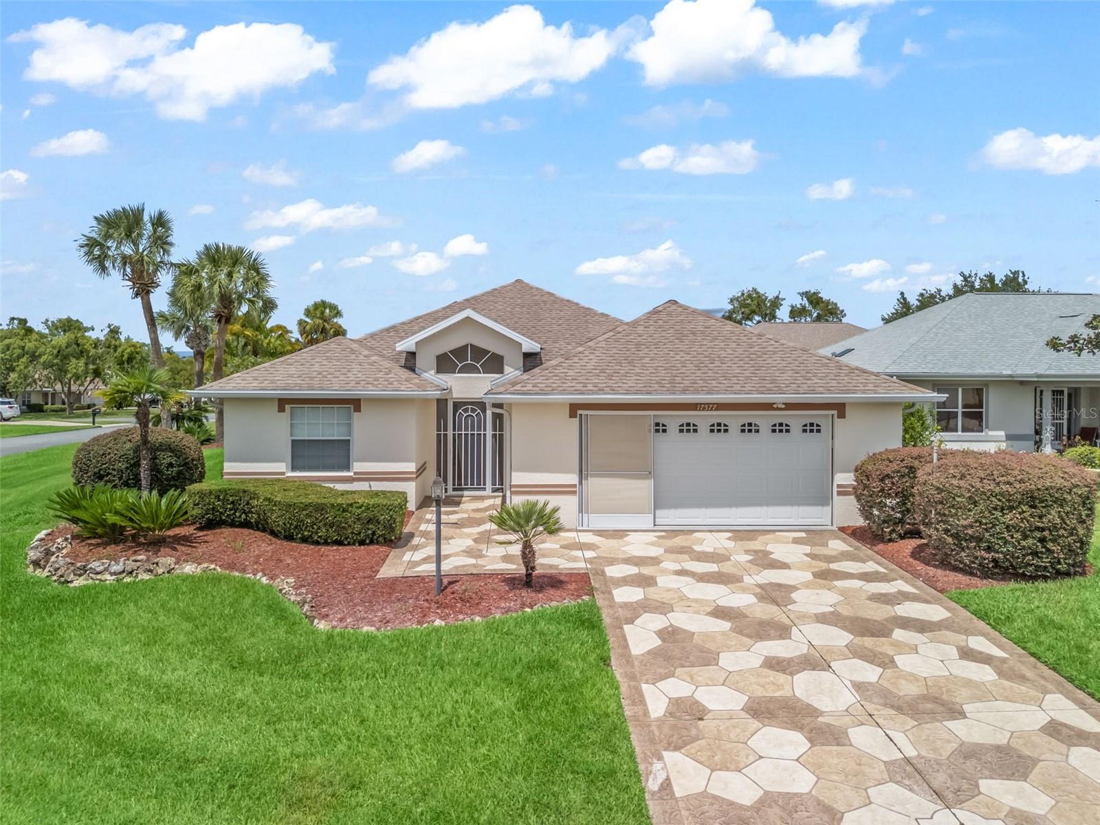 One or more photo(s) has been virtually staged. Stonecrest is a 55+ gated golf course community with all the amenities and 4 pools (one indoor), and just a Bridge Away By Golf Cart To The Villages! Exceptional 3/2 Concrete, Block & Stucco Pebble Beach model with an Oversized 24 x 30 2 Car Garage on a Large Corner Lot offers The Anker Solix F-3800 Whole House Solar system (a 2 Solar Generator system with 4 additional backup batteries to power whole house in a power outage or when there is no outside sunlight. Installed 12/2024, and was paid in full at the time of installment), The Solar Panel system is by Sunnova Systems which powers the whole house when there is sunlight, and charges the Anker Solix system (25 year lease on the Sunnova System solar system is fully paid, with no additional payments needed Installed 2020). Newer HVAC 2022, Whole House Water Filtration System, ROOF 2019, No Carpet, an Open Concept Floor plan, and Tremendous Curb Appeal featuring Meticulously Maintained Low Maintenance Landscaping, Designer Stamped Concrete Driveway and Walkway, and a Gated Front Entrance with a Leaded Glass accented Front Door! Upon entering into the foyer, you are greeted by an Elegant Designer Light fixture, with the Dining and Living area combination both showcasing Gorgeous Upgraded light fixtures, Vaulted ceiling and Glowing Engineered Hardwood Flooring! The Open Concept Floor plan creates a Spacious Gathering Area, perfect for Entertaining Family & Friends! The Living area flows seamlessly through stackable sliding doors to the Glass Enclosed Lanai with Tile flooring, Enhancing the Additional Living Space Experience! The Open Kitchen is bathed with natural light featuring Vaulted ceiling, Engineered Hardwood flooring, a Pantry closet, Granite countertops, Tile backsplash, Black Stainless Appliances, plenty of Wood cabinets, Plantation Shutters, and an Eat in Aera! The Luxurious Primary bedroom offers Engineered Hardwood flooring, a Walk in Closet, and an En Suite bathroom. The En Suite bathroom boasts a Double Sink Vanity with a Granite countertop, Tub, and a Tiled Walk in Shower. The Second Bedroom features a nice size built in closet, engineered hardwood flooring, and the Third Bedroom (no closet) provides an elegant French door entry, Plantation Shutters, and Beautiful engineered hardwood flooring, both bedrooms offering plenty space for your guests, with the Guest bathroom showcasing a Granite topped vanity, and a stunning Tiled Shower. Enjoy Your Own Private Retreat on the Glass Enclosed Lanai showcasing beautiful tile flooring, and perfect for enjoying Evening Dining, Beautiful Florida Sunsets, and Tropical breezes! You will love having plenty of room for storage in the freshly painted Oversized 24 x 30 2 Car Garage with Built in Storage cabinets, Mitsubishi Mini Split, Insulated Garage doors, and Epoxy flooring! This Stunning Concrete Block & Stucco Pebble Beach model has Privacy landscape, which provides a lovely parklike setting for your backyard BBQ's! Stonecrest is a 55+ gated golf course community with all the amenities, pools, pickleball courts, softball, 18 hole championship golf course, Broad Stripes Golf & Social Club and over 80 different clubs to join! It is a community with Private Roads and 24 Hour Security! Overall, this home offers Luxurious Features, Upgrades, a Desirable Location, and a Secure Community Setting. A WONDERFUL LIFESTYLE AWAITS YOU IN STONECREST!