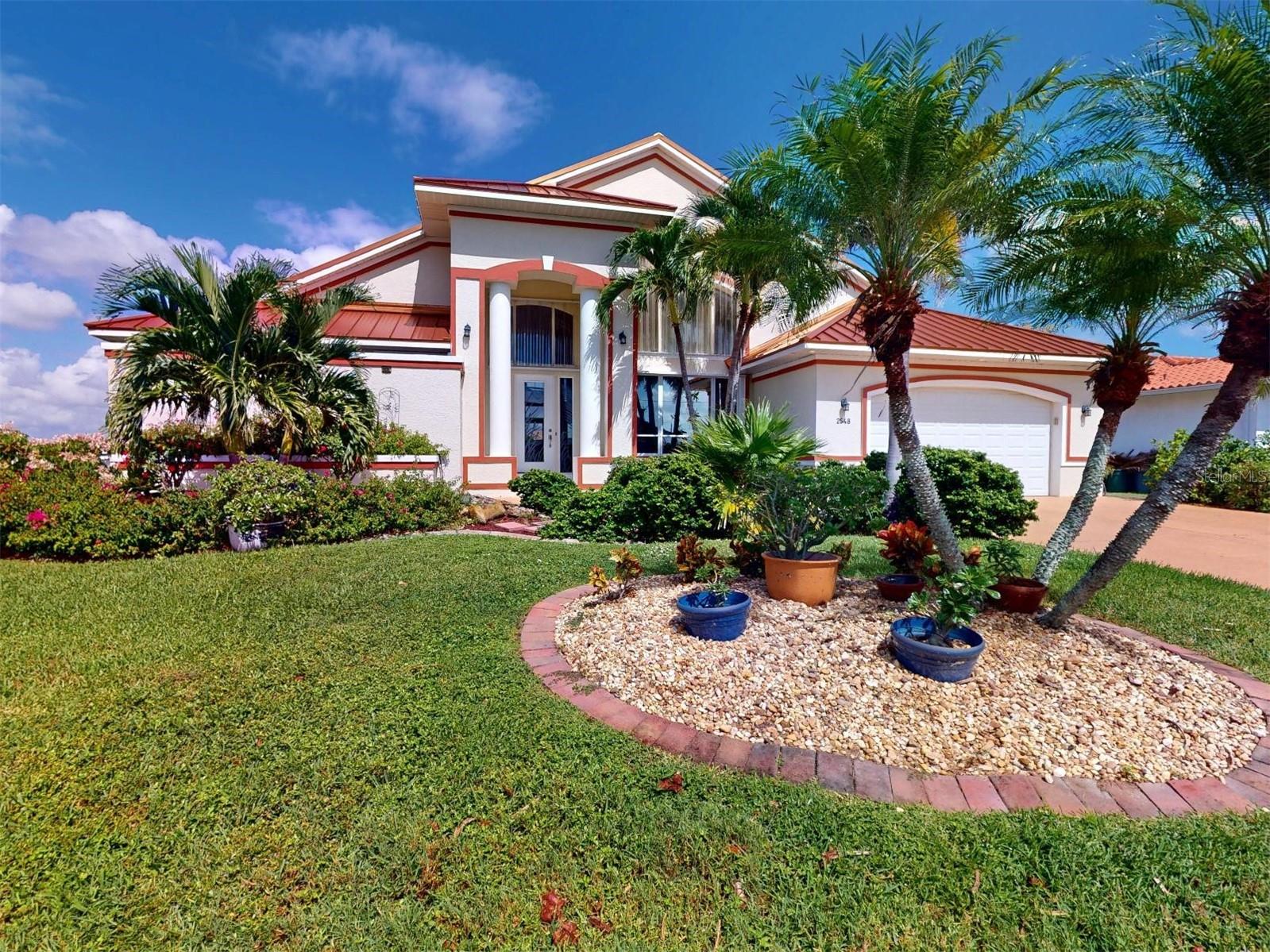 Welcome to 2548 Brazilia Court in Beautiful Punta Gorda Isles. This extraordinary sailboat home, boasting over 2700 living square feet, encompasses dramatic architectural features while capturing the beauty of wide panoramic views of intersecting waterways. Five minutes from Ponce Inlet, the location is a boater's delight. Enjoy a 50' concrete dock with new pilings and a 10k boat lift so you can cruise Charlotte Harbor or head to the Gulf of Mexico. Soaring 18 ft. ceilings, 8 foot sliding glass doors and transom windows bring the outdoors in with an abundance of natural light. Granite counters in the kitchen and baths, 20" tile floors throughout. Enjoy a gourmet kitchen with large center island and double ovens (one is convection) and sub zero fridge, great for large parties. Kitchen has had a recent upgrade with soft close doors and drawers along with counters. The eat-in-kitchen with an aquarium glass beveled window overlooks the large heated pool and brick paved lanai area. The garden master bath offers a clear glass enclosed shower and Jacuzzi tub, double sinks and beautiful granite counter tops. Your guests will love the extra large bedroom suites and guest bath. The Family room which has access to the pool could also be used as a large game room. And to top it all off the Solar panels will keep those electric bills at a minimum for many years to come.