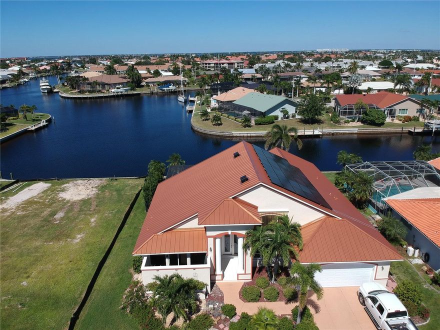 Welcome to 2548 Brazilia Court in Beautiful Punta Gorda Isles.  This extraordinary sailboat home, boasting over 2700 living square feet, encompasses dramatic architectural features while capturing the beauty of wide panoramic views of intersecting waterways. Five minutes from Ponce Inlet, the location is a boater's delight. Enjoy a 50' concrete dock with new pilings and a 10k boat lift so you can cruise Charlotte Harbor or head to the Gulf of Mexico. Soaring 18 ft. ceilings, 8 foot sliding glass doors and transom windows bring the outdoors in with an abundance of natural light. Granite counters in the kitchen and baths, 20" tile floors throughout.  Enjoy a gourmet kitchen with large center island and double ovens (one is convection) and sub zero fridge, great for large parties. Kitchen has had a recent upgrade with soft close doors and drawers along with counters. The eat-in-kitchen with an aquarium glass beveled window overlooks the large  heated pool and brick paved lanai area. The garden master bath offers a clear glass enclosed shower and Jacuzzi tub, double sinks and beautiful granite counter tops. Your guests will love the extra large bedroom suites and guest bath. The Family room which has access to the pool could also be used as a large game room. And to top it all off the Solar panels will keep those electric bills at a minimum for many years to come.