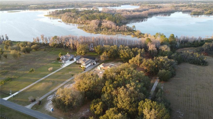 Lakefront Paradise on Skiable Pine Island Lake — Over 2 Acres with Canal Frontage! Seize this rare opportunity to own over 2 acres of direct lakefront property on skiable Pine Island Lake, complete with a canal running along the right side of the property for added waterfront access. This stunning homesite is partially cleared and ready to build, nestled among majestic oak and cypress trees, offering both natural beauty and privacy. With no HOA, you have the freedom to create your own secluded oasis. Bring your boats, jet skis, and water toys to experience the ultimate lakefront lifestyle. Don’t miss out on this one-of-a-kind property!