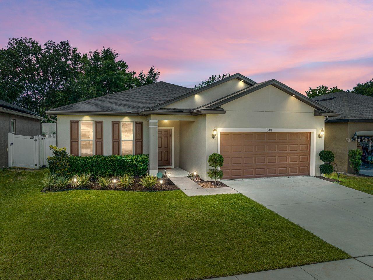 BETTER THAN NEW - SO MANY ENHANCEMENTS! Welcome to your stunning new home in the Polk City neighborhood of Fountain Park! This beautiful property offers 3 BR/2 BA, plus an office or formal living room, all spread across a spacious 1,978 square feet of living space. Built in 2021, this home is practically brand new and features modern finishes throughout. As soon as you step inside, you'll be struck by the open and inviting floorplan. The family room seamlessly flows into the dining area and kitchen, making it the perfect space for entertaining guests or just hanging out with family. The entire home is carpet-free, having either tile or wood laminate flooring that features a thermal underlayment, providing both style and comfort. This home is a true "smart" home, with every detail meticulously planned for the ultimate in convenience and comfort. From the door locks and thermostat to the light fixtures, stove, fridge, and irrigation system, everything can be controlled remotely with ease. Additionally, hard-wired interior and exterior cameras offer peace of mind and security. The completely fenced backyard provides the perfect spot for outdoor relaxation and privacy, with 6' PVC privacy fencing, a covered lanai, and a cozy firepit, complete with 6 Adirondack chairs just waiting for you! Inside the home, you'll find a range of high-end features and finishes, including an epoxy-coated garage floor, recessed lighting in the soffit all the way around the house, wood shelving in the pantry, and a professionally-designed closet system in the primary bedroom closet. Soft-close hinges on all cabinets and drawers, granite counters, and a drop station in the laundry room all add to the feeling of luxury and convenience. Located just off of I-4, this home offers the ultimate in convenience, with easy access to both Tampa and Orlando. Don't miss out on this amazing opportunity to own a truly exceptional home!