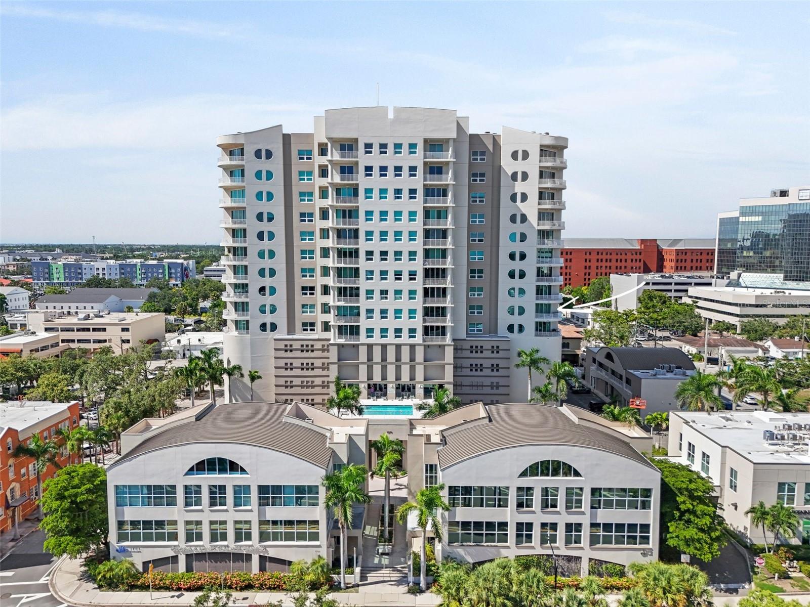 Welcome to Rivo at Ringling, a contemporary downtown Sarasota retreat where sophisticated design meets an ideal location. Originally inspired by the sleek elegance of luxury yachts, this 15-story architectural gem was conceived by renowned father-and-son team Piero and Renzo Rivolta and offers just 106 exclusive residences. The unique design of the building centers around a soaring atrium and central ground level conservatory featuring multiple community gathering spaces. Nestled in the heart of Sarasota, Rivo provides the perfect balance of a curated lifestyle—close enough to enjoy the vibrant dining, boutique shopping, cultural attractions, and entertainment of downtown, yet tucked away from the hustle & bustle of the vibrant nightlife scene found on Main Street and St. Armands Circle. World-class beaches, including Lido & Longboat Key, are just a short bike ride or drive away, making this residence the perfect launch point for both urban living and beach day escapes.
This move-in ready, fully updated residence is truly one of a kind—offering more than 2,000 sq. ft. of interior living space and an additional 160 sq. ft. balcony overlooking the city skyline with panoramic views of downtown and peek-a-boo glimpses of Sarasota Bay. Soaring 9’ ceilings and signature Rivo demi-circle windows fill the home with natural light, highlighting the chic, modern updates and freshly painted interiors.
The rare true 3-bedroom condo floor plan sets this unit apart as one of the best values in downtown Sarasota. Inside, you’ll find engineered hardwood floors throughout, automated custom window treatments, and a luxurious primary suite, featuring a spa-inspired bath and custom-built closet system. Designed with entertaining in mind, the open-concept layout flows seamlessly into a gourmet kitchen appointed with high-end appliances and a clean, modern aesthetic, making it the perfect setting for gatherings with family and friends. Every detail has been thoughtfully designed to provide both elegance and comfort—nothing left to do but unpack your suitcases.
Rivo at Ringling offers residents a rich collection of amenities, including a state-of-the-art fitness center, heated pool and spa, conference space, and community room. The building is secured with concierge service and provides two deeded parking spaces plus two dedicated storage spaces with this residence.
This is more than a home—it’s a lifestyle, offering refined downtown living with the best of Sarasota and the Gulf Coast at your doorstep.