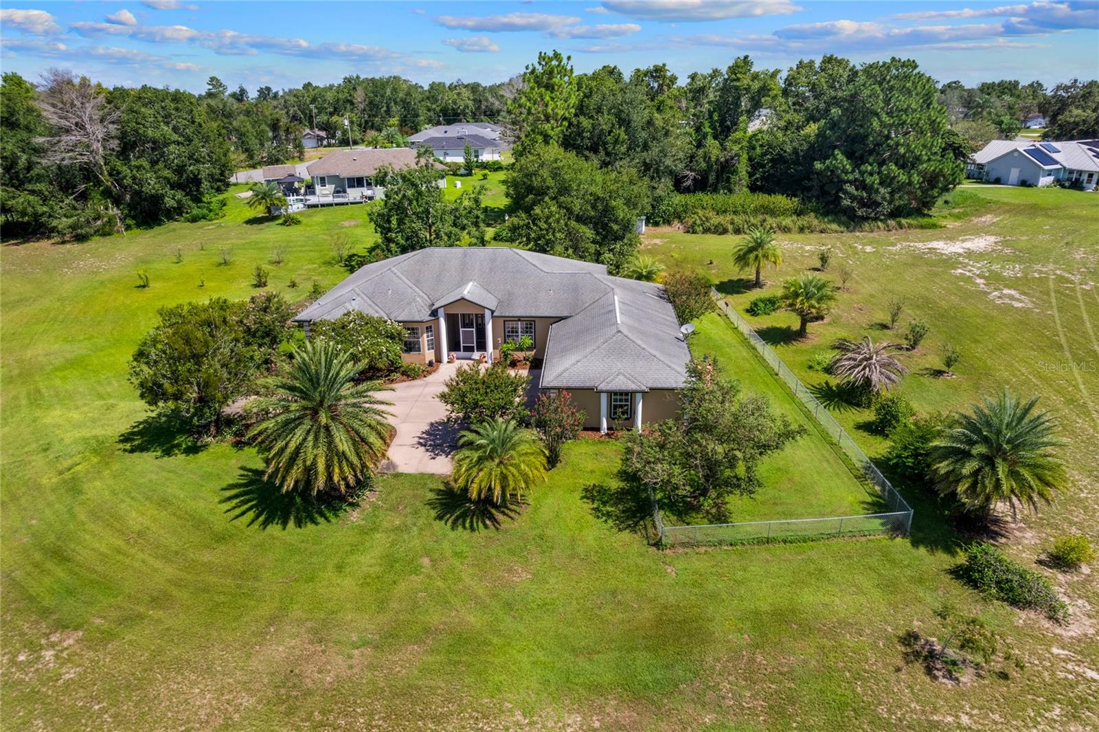 Welcome to your piece of paradise including an 8-acre property with cement block construction, stucco exterior, and fresh paint inside and out. Enjoy the spacious 3,020 sq. ft. finished living space with 4 bedrooms, 3 bathrooms in this custom-built home with vaulted ceilings, the master suite with large walk-in closet, en suite bathroom featuring jetted tub and roman-style walk-in shower with two shower heads is sure to please. On the other side of the split floorplan, you will find 2 bedrooms with shared Jack & Jill bathroom and pocket doors (standard closets). Additional large bedroom with standard closet and full bathroom across the hall (also serves guests), formal dining room off the living room. This is a pet friendly layout with dog door from kitchen to screened lanai and from lanai to covered patio with exterior ceiling fan. A large 3-car garage (825 sq. ft.) with attached laundry room awaits your vehicles and/or toys with plenty of additional storage.
Outdoor features include screened-in back lanai and screened-in front vestibule large fenced yard encompassing rear and side of home (approx. 1 acre irrigated with six zones), water fountain in backyard with continuous fresh water supply and electricity, seven mature palm trees and mature gardenias, organic blueberry hedge (approx. 120 sq. ft.), fruit trees: 3 young Plouhari trees (plum-cherry hybrid, fruiting in early spring), 2 young apple trees (not yet fruiting).
Previously operated as a plant nursery - extensive underground irrigation remains, with four water spigot locations, 2,400 sq. ft. metal building with concrete floor, electric, and plumbing (ideal as workshop, office, or storage), large chicken coop (16' x 8' x 8') with fenced run, automatic sunrise/sunset door, and water supply. - Mature live oaks, cleared and maintained grass throughout and a private driveway to property make this a MUST see!
ADDITIONAL OPTIONS
- Adjacent 0.37-acre lot available for purchase, providing additional residential access point for improved ingress/egress
- Option to purchase farm equipment, including:
- Yanmar diesel 40-horsepower tractor, finish mower deck, one plow, disc for disking the field, rake for raking the field